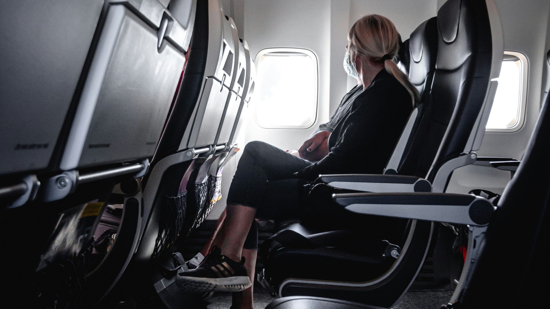 a woman sitting in a seat on an airplane