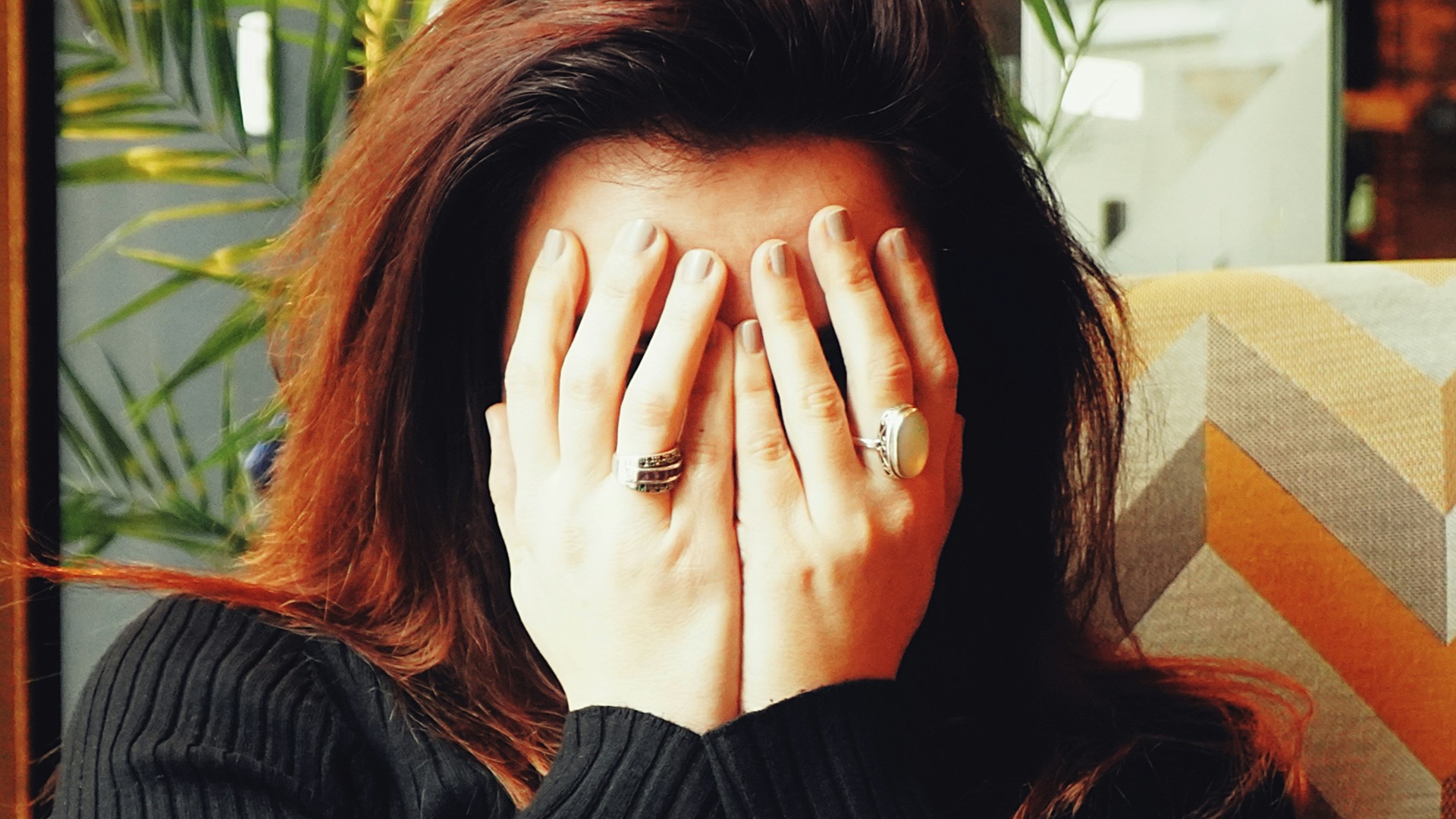 woman in black long sleeve shirt covering her face