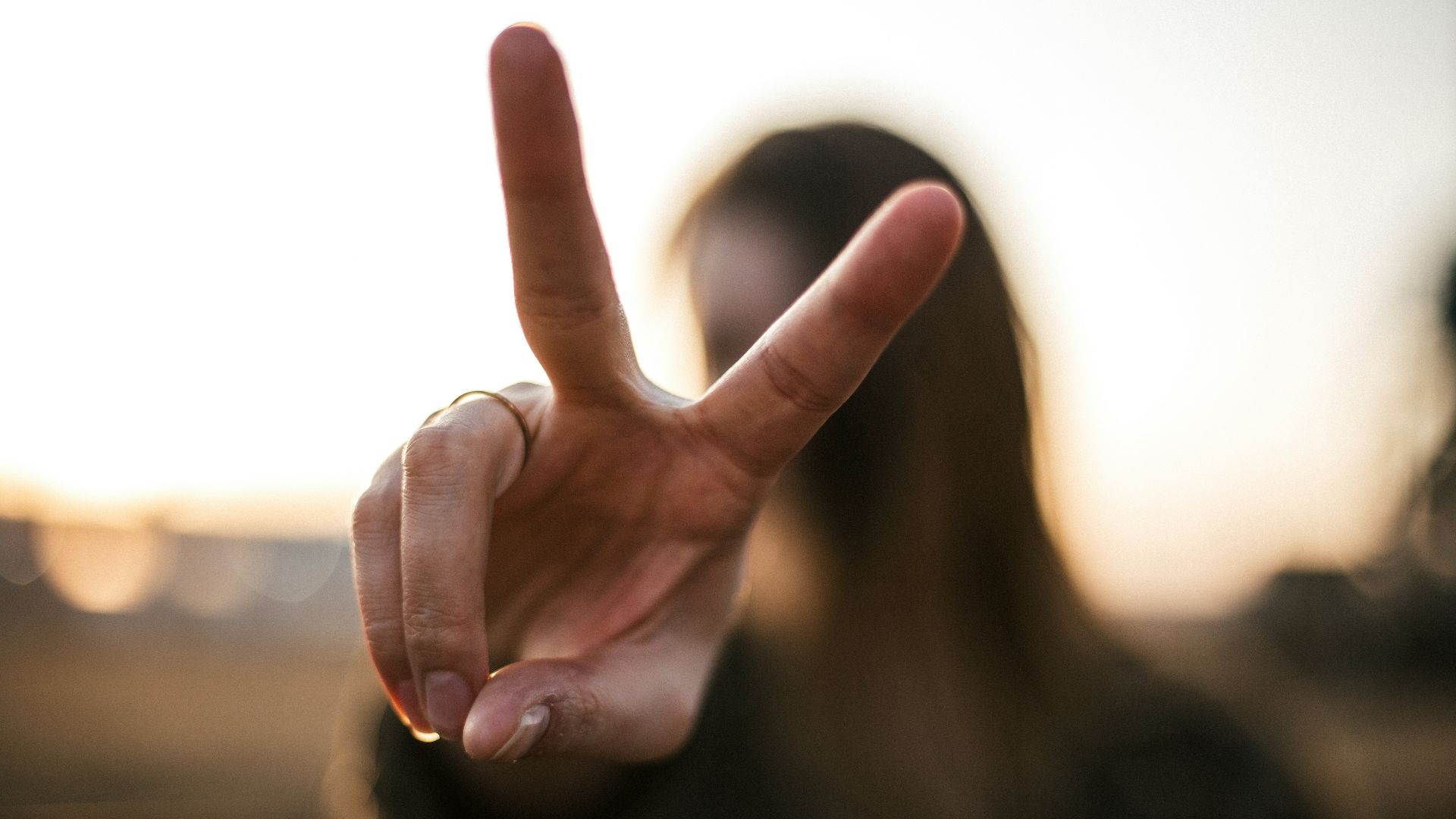 focus photography of woman hand with peace sign
