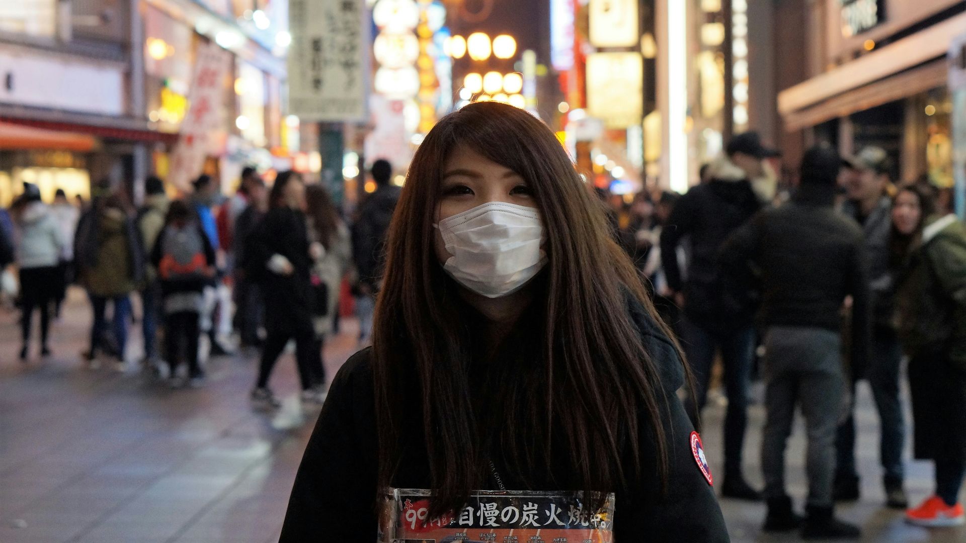 woman in black hoodie wearing white mask