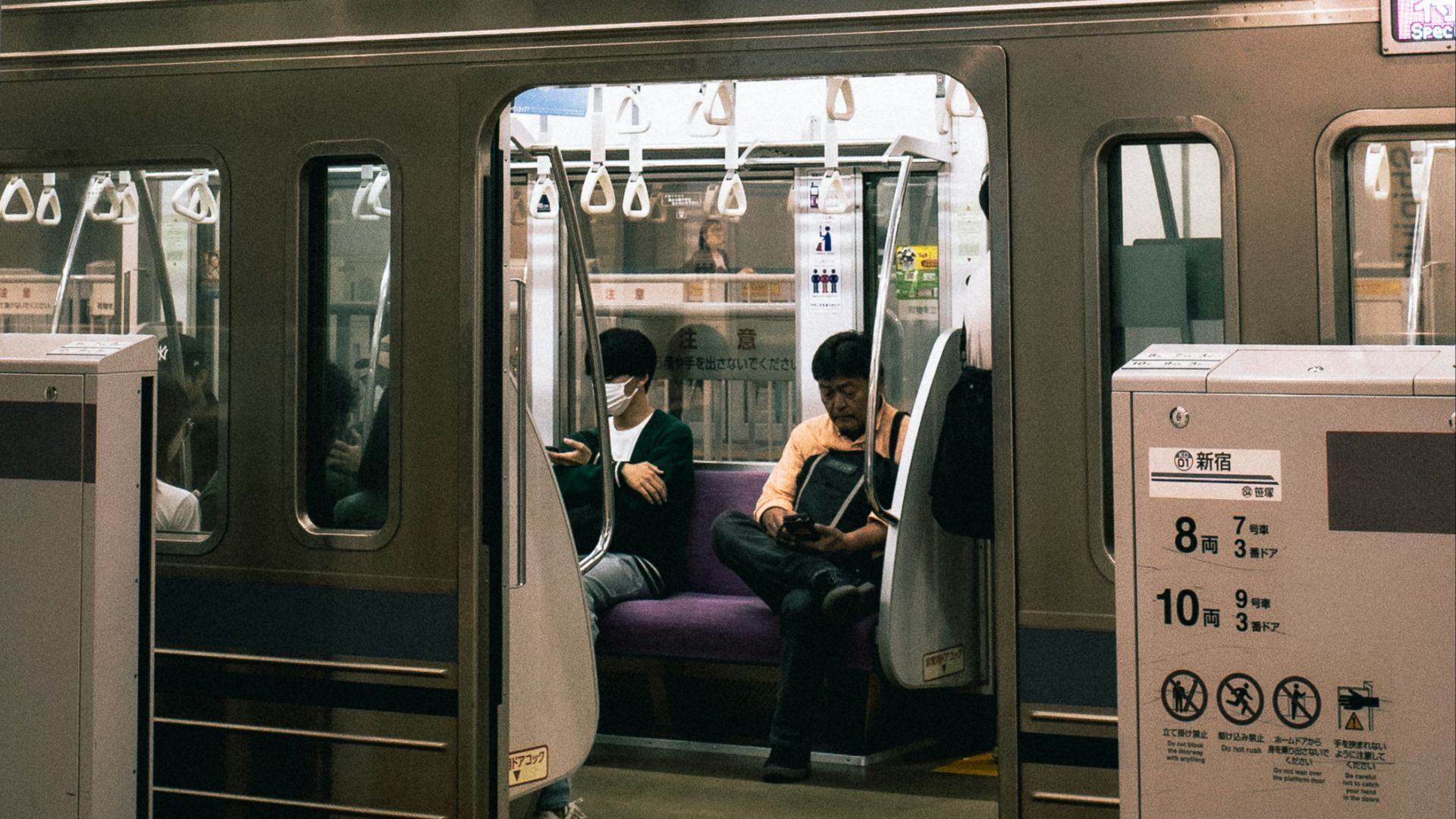 A subway car with people sitting in it