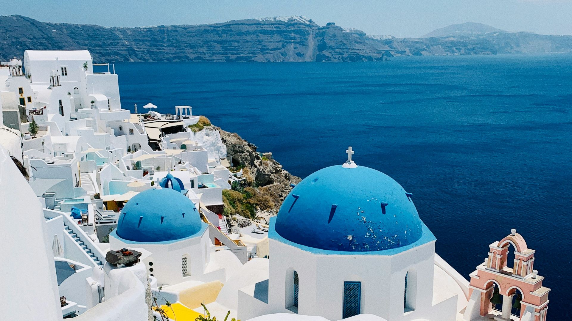 a view of a blue domed building on the edge of a cliff