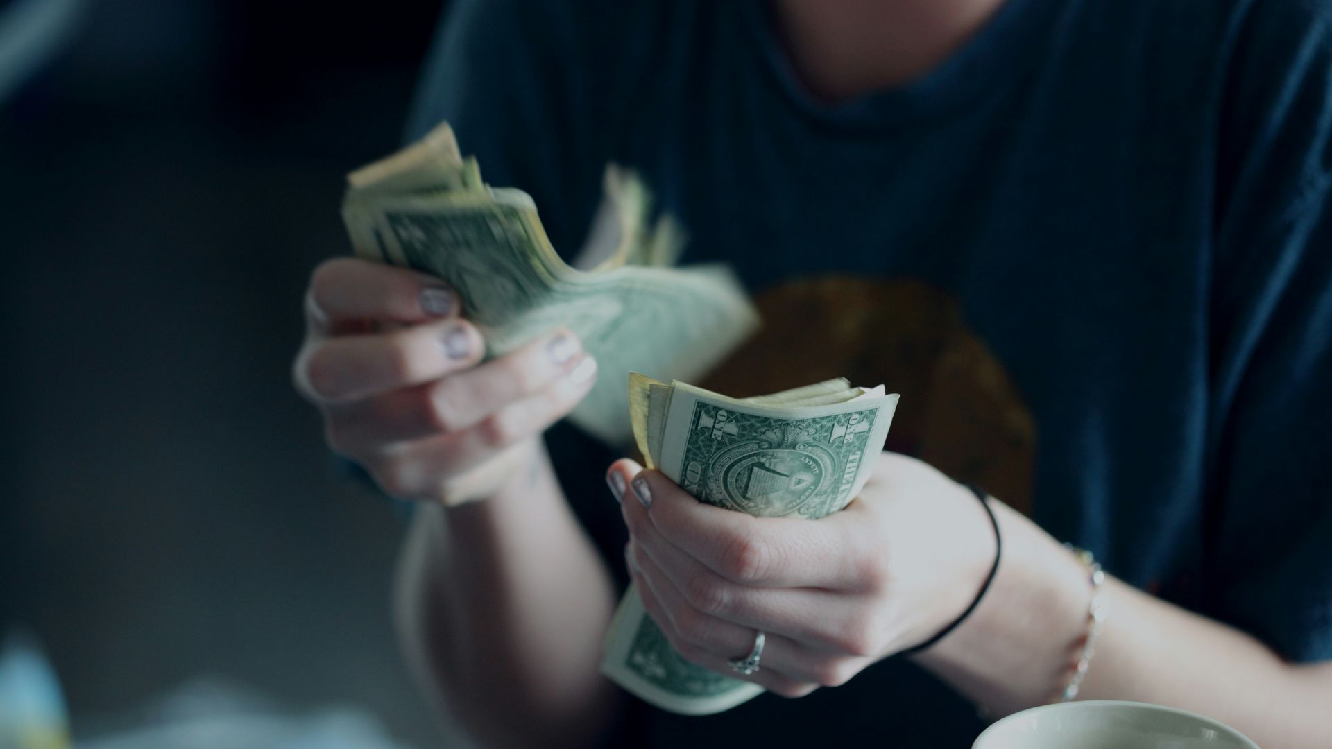 focus photography of person counting dollar banknotes