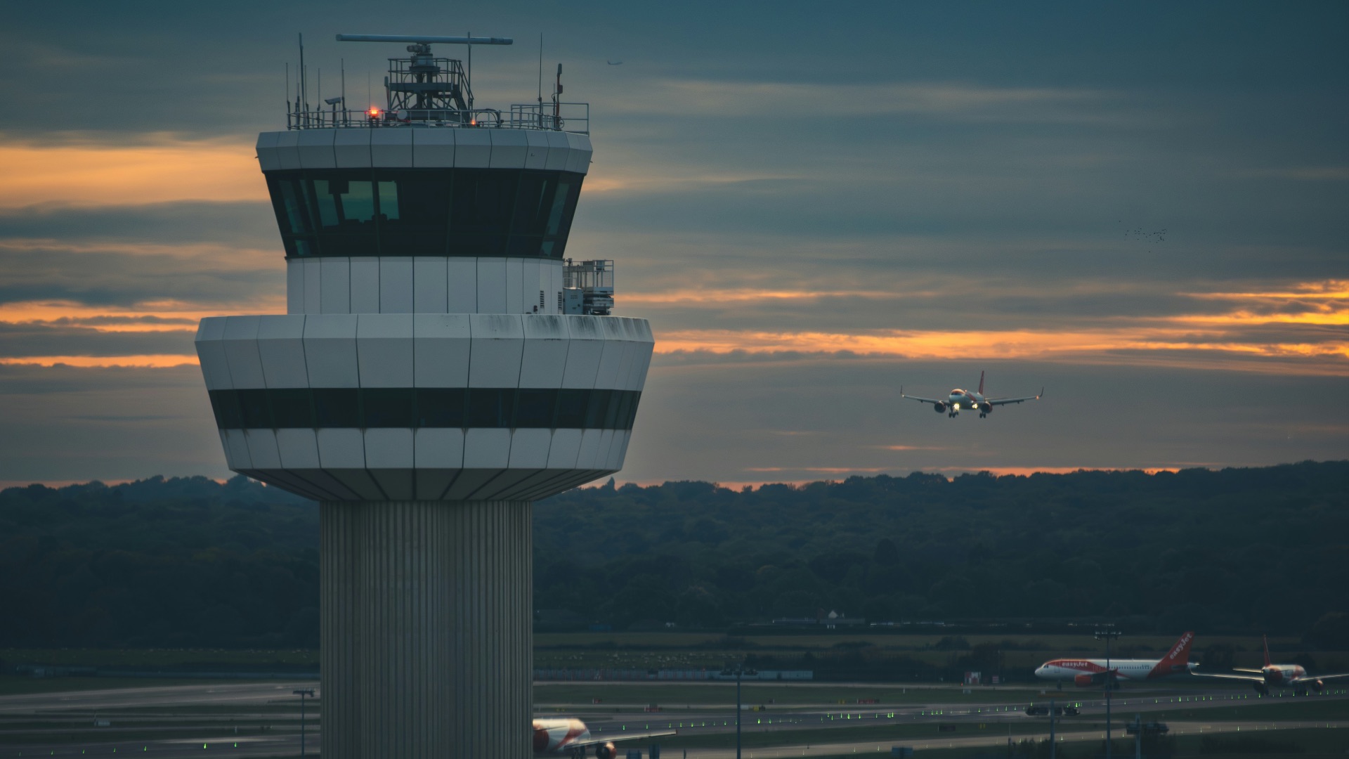 A large air plane flying over a runway