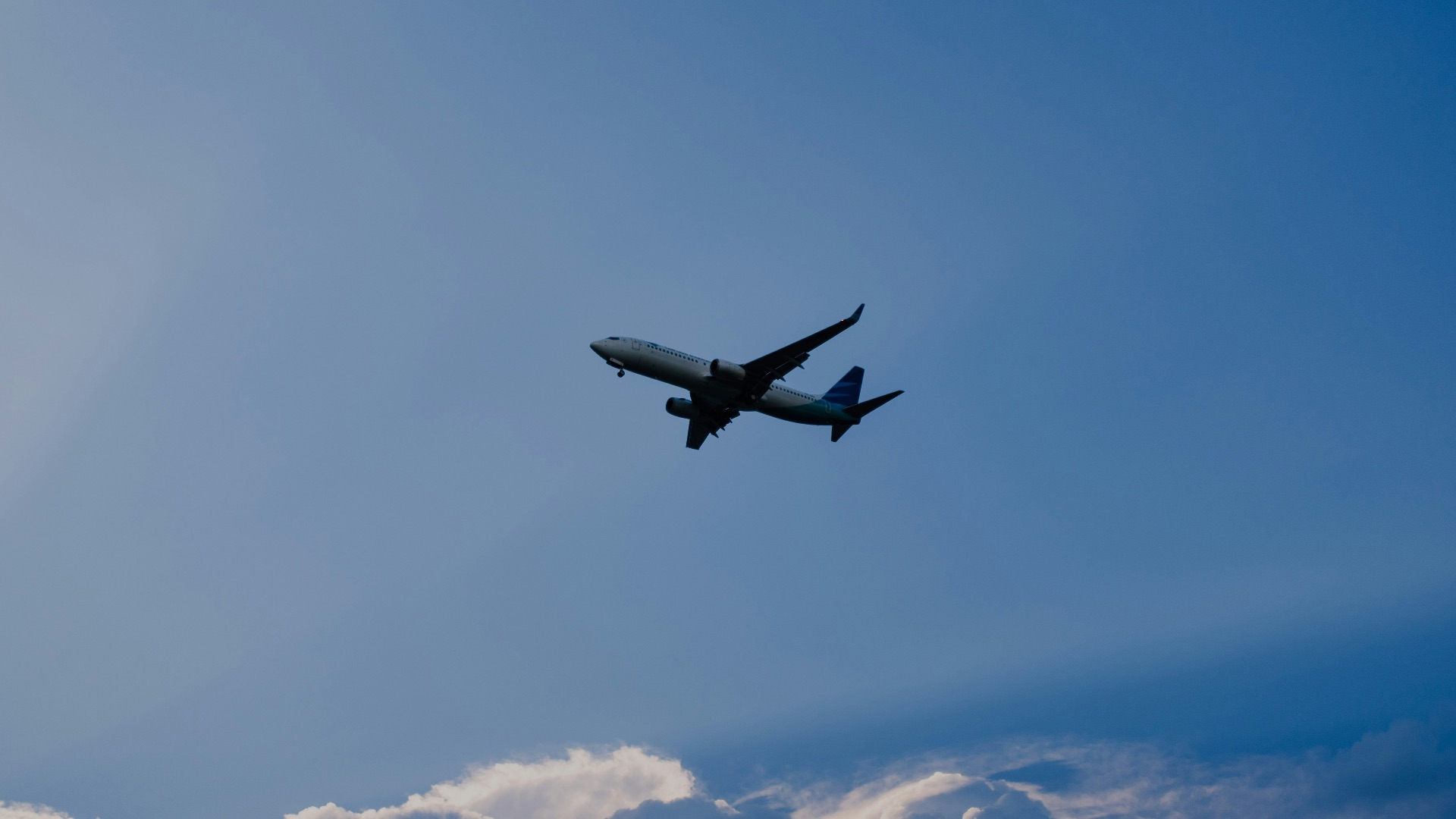 airplane flying under blue sky