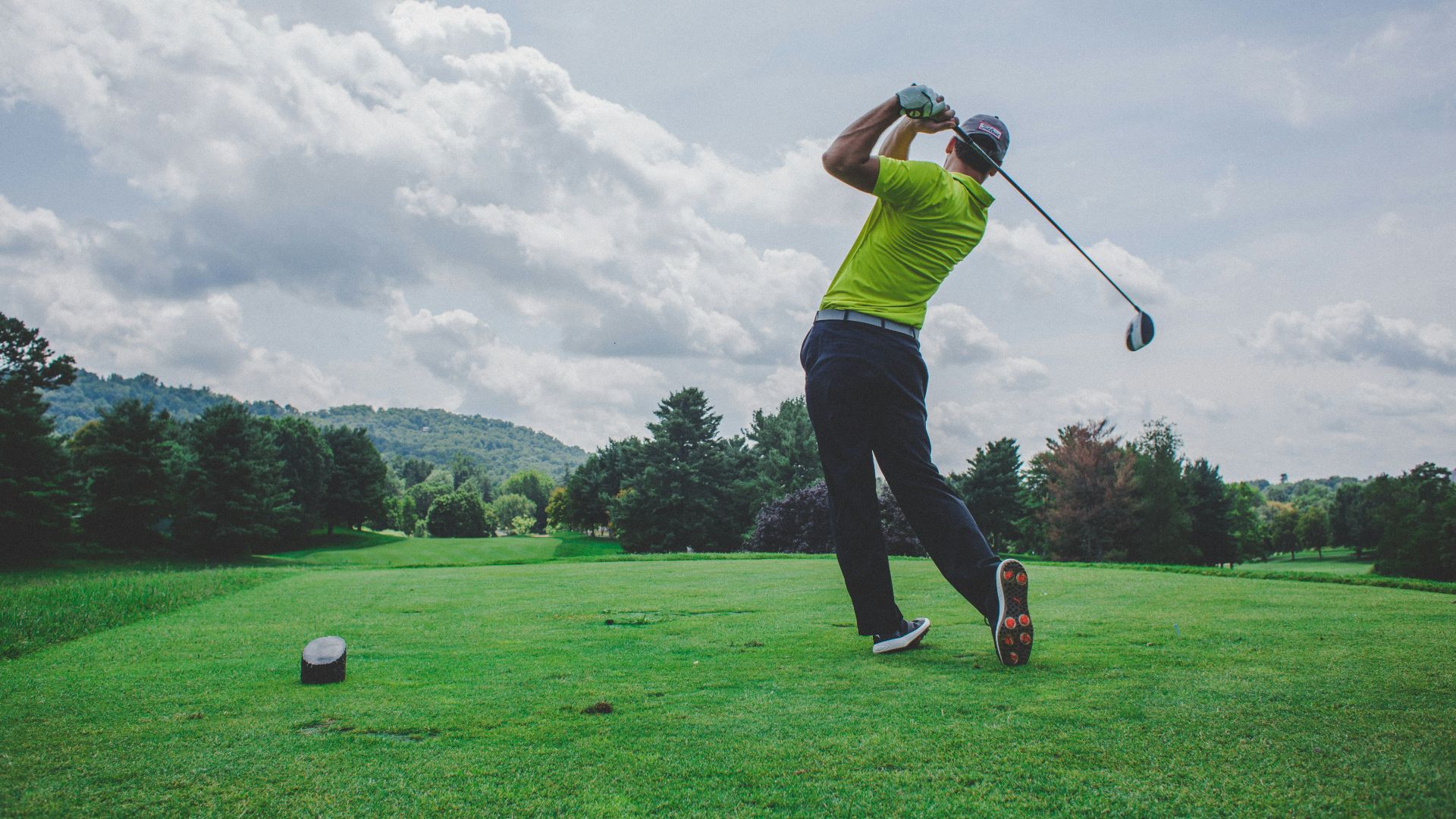 photo of man swinging golf driver