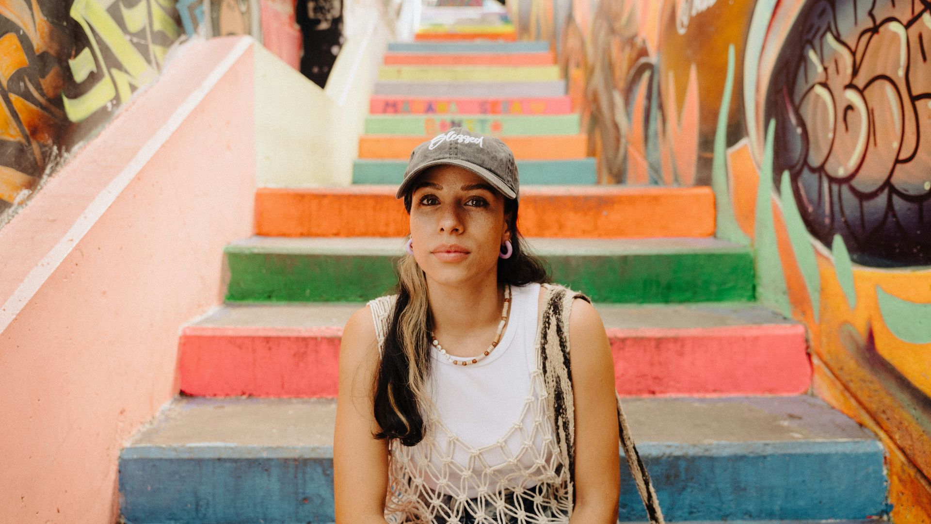 a woman sitting on the steps of a colorful staircase
