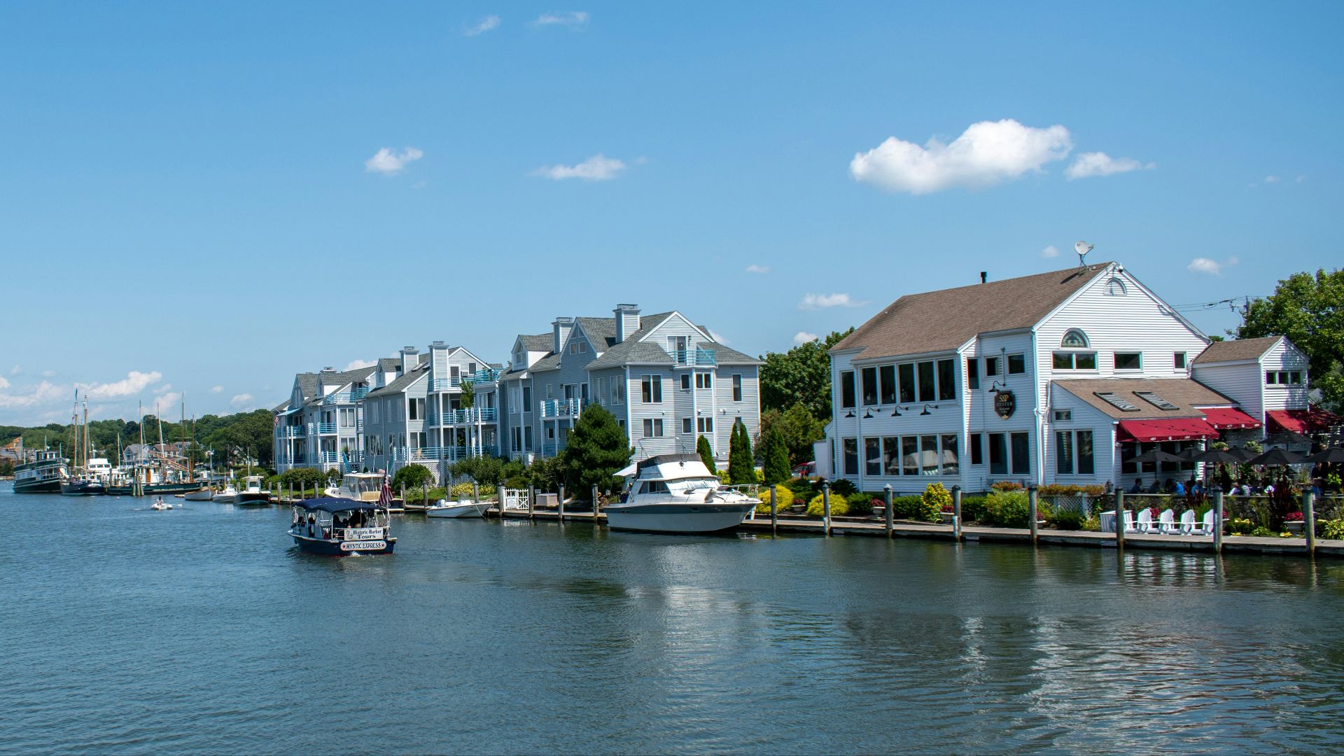white and black boat on sea near city buildings under blue sky during daytime
