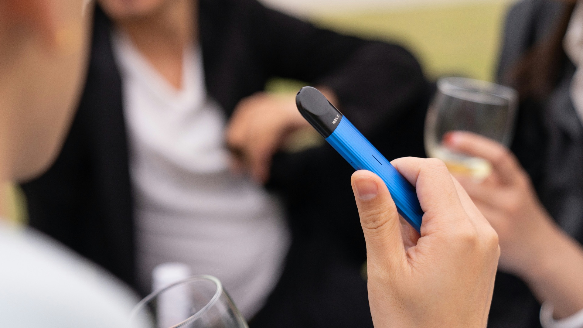 woman in white long sleeve shirt holding blue pen