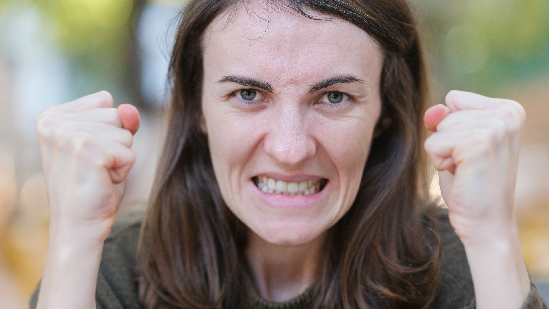 a woman holding her fists up in the air