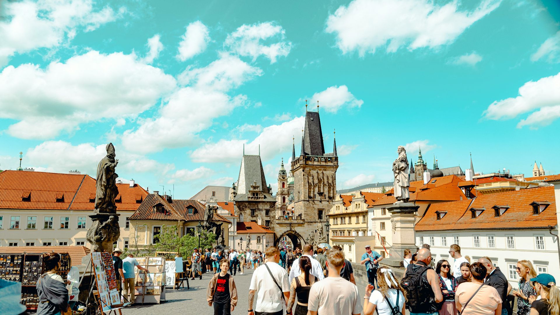 A group of people walking down a street next to tall buildings