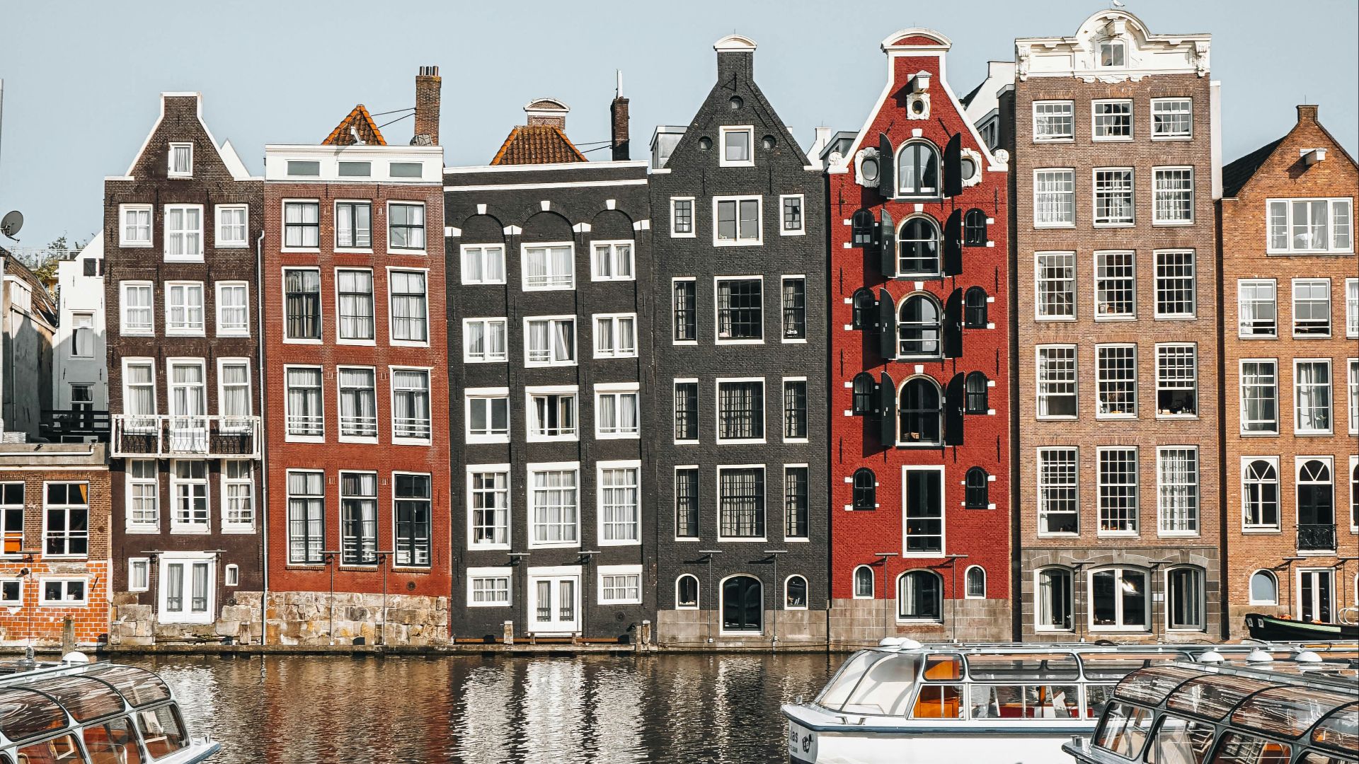 white and brown boat on water near brown concrete building during daytime