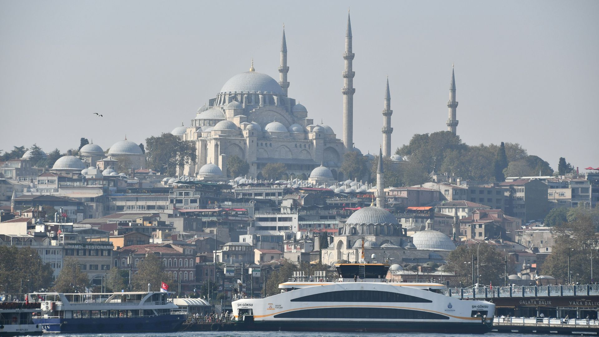 a large boat in the water near a city