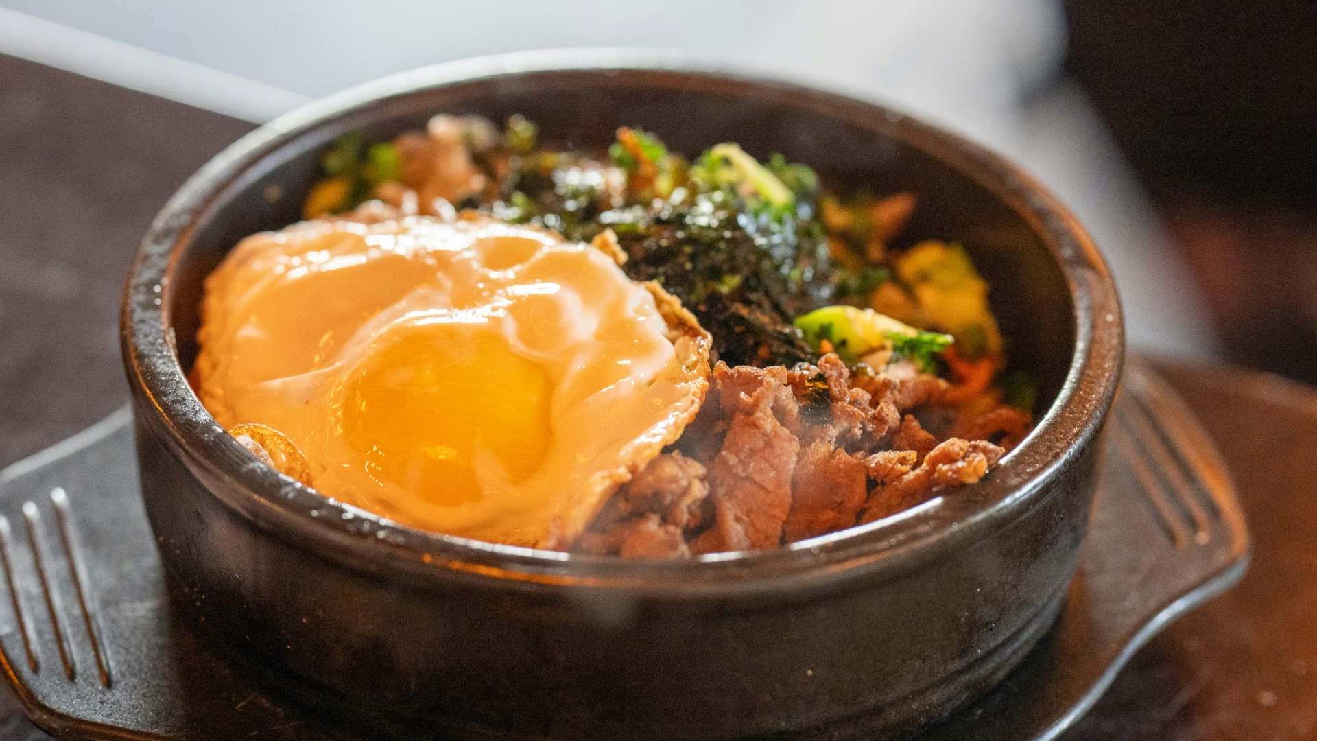 a bowl of food sitting on top of a wooden table
