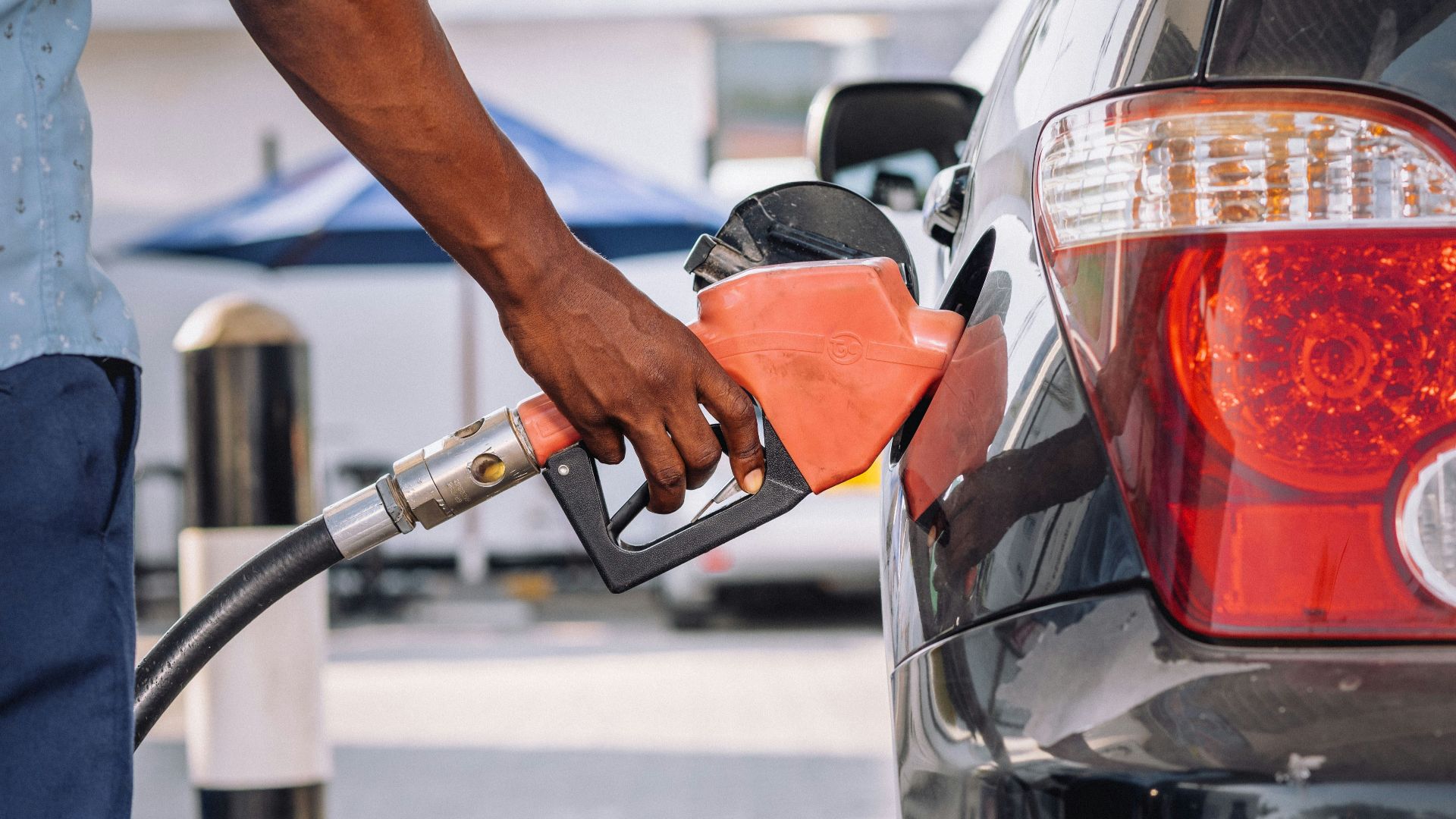 a man pumping gas into his car at a gas station