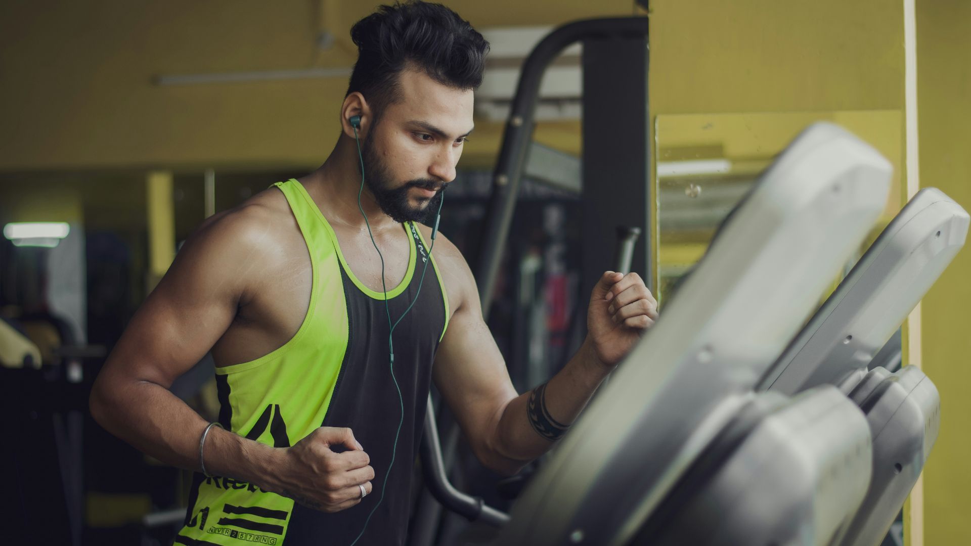 man in green tank top sitting on black chair