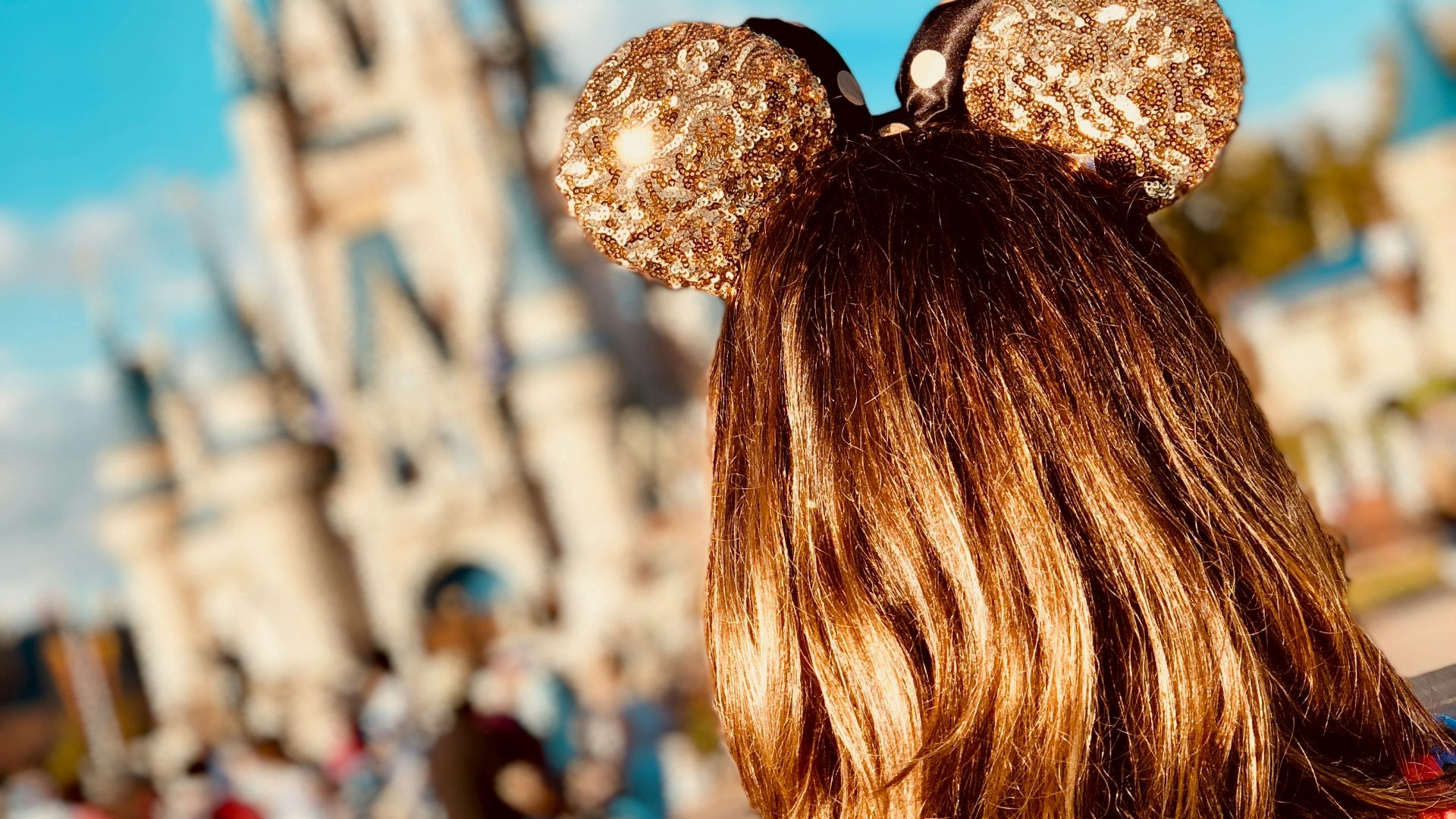 woman wearing golden Mickey Ears at Disneyland