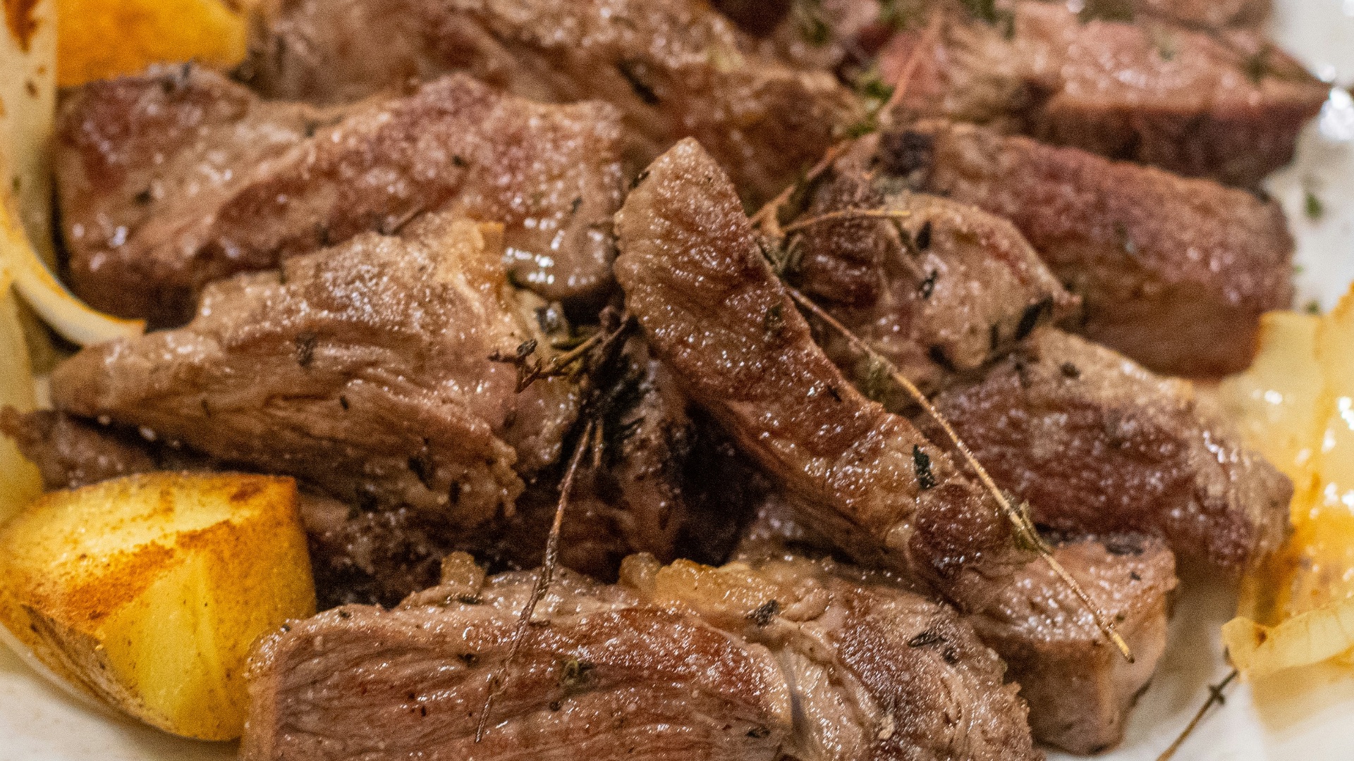 a white plate topped with steak and potatoes