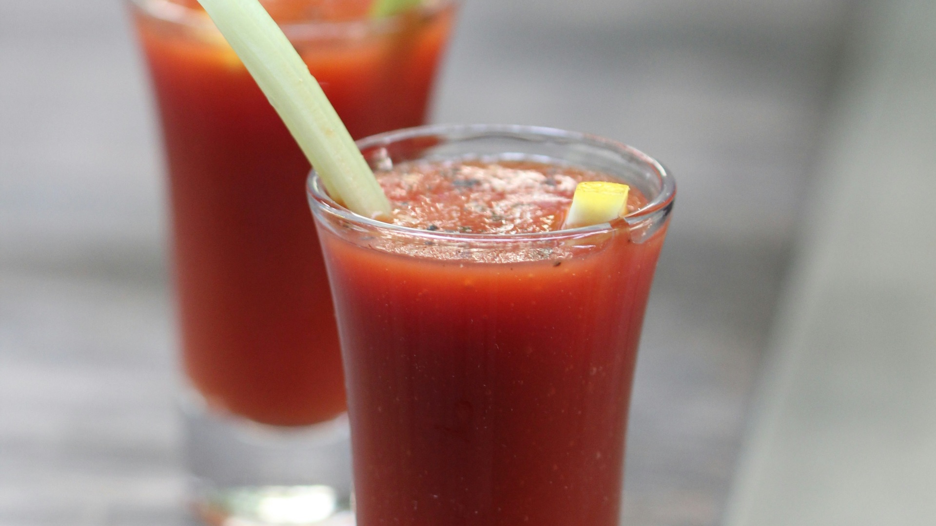 clear drinking glass with red liquid and green straw