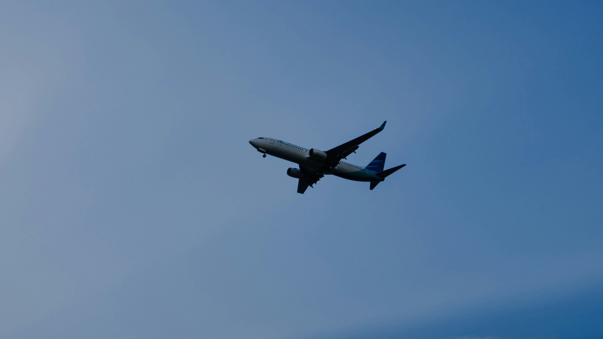airplane flying under blue sky