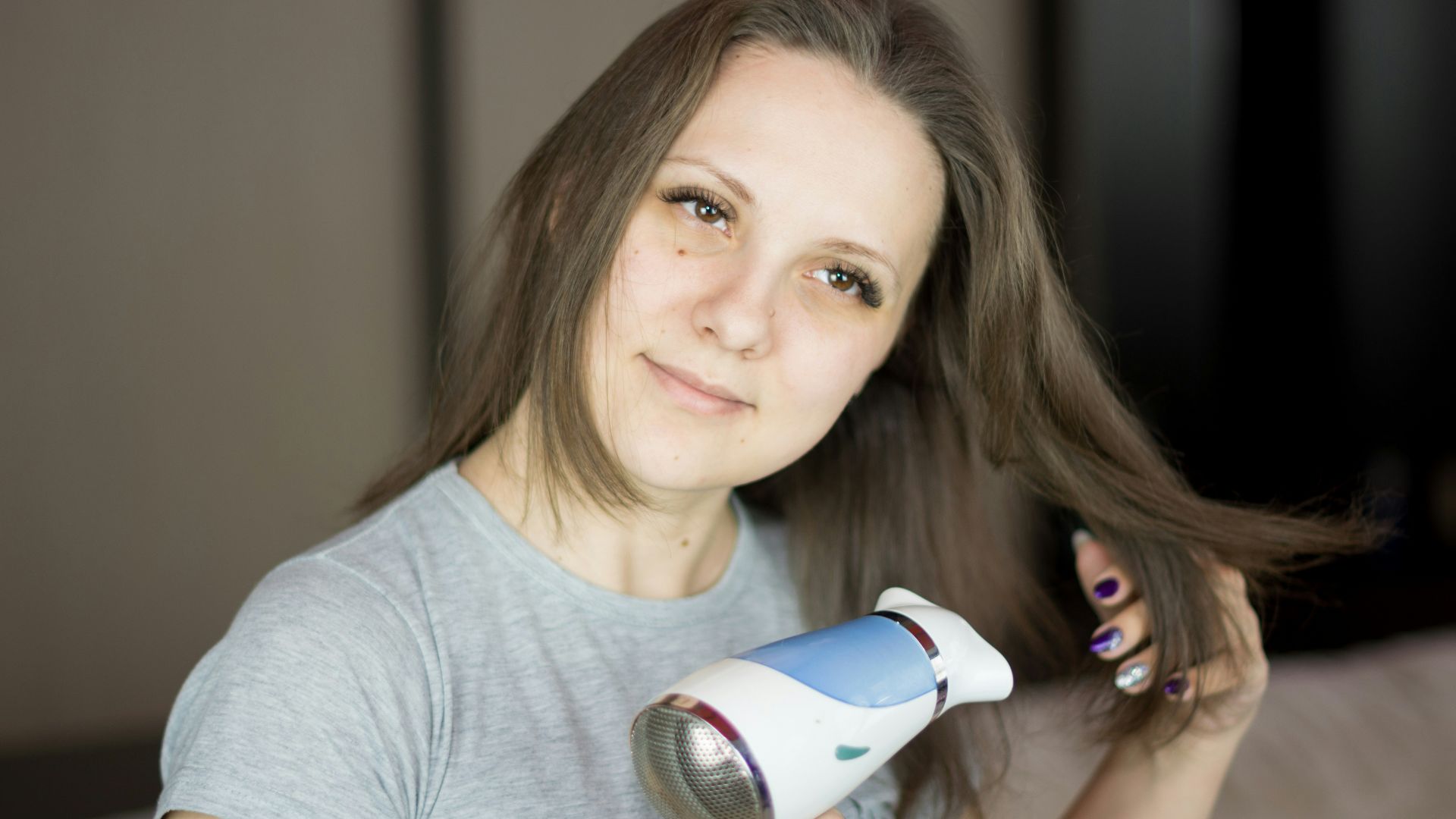 a woman blow drying her hair with a hair dryer