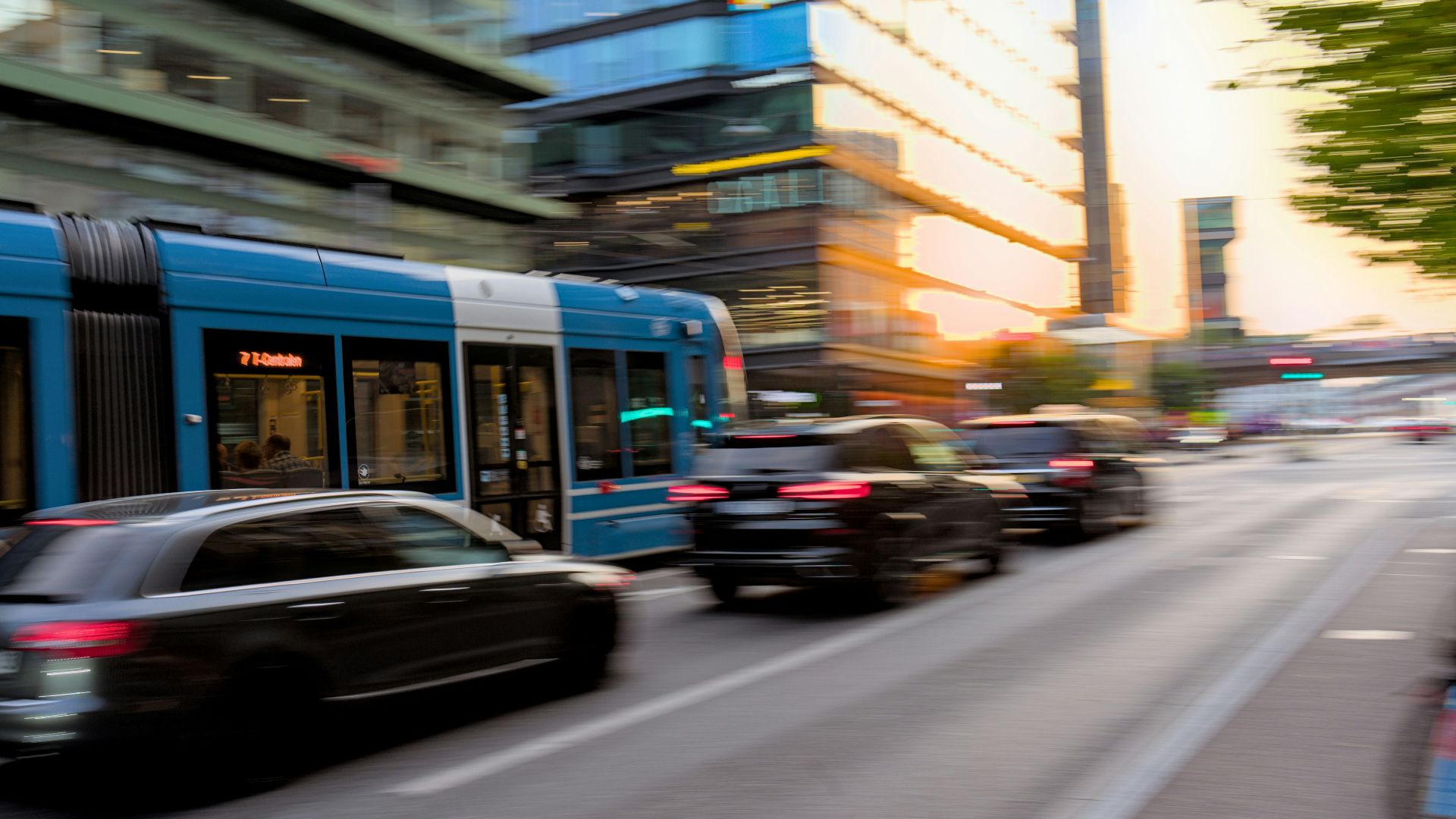 a city street filled with traffic next to tall buildings