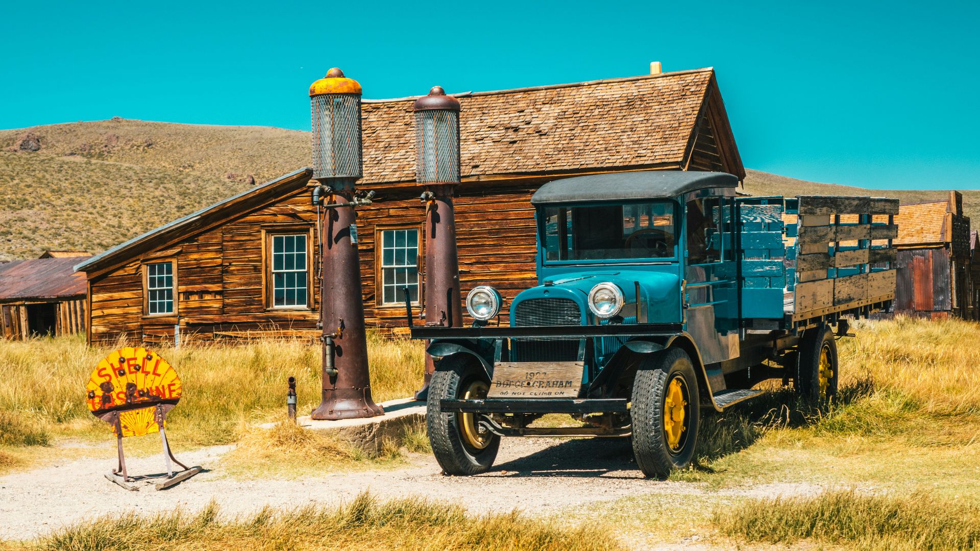 green and black vintage car parked beside brown brick building during daytime