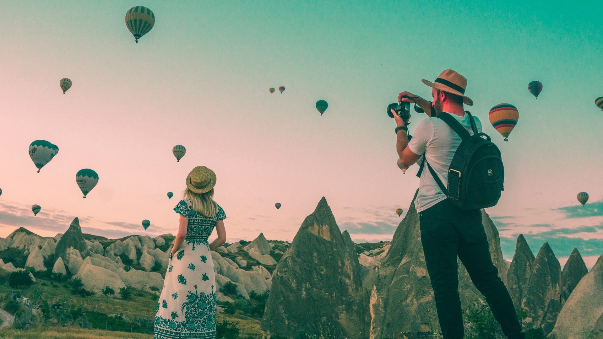 man taking photo of hot air balloons