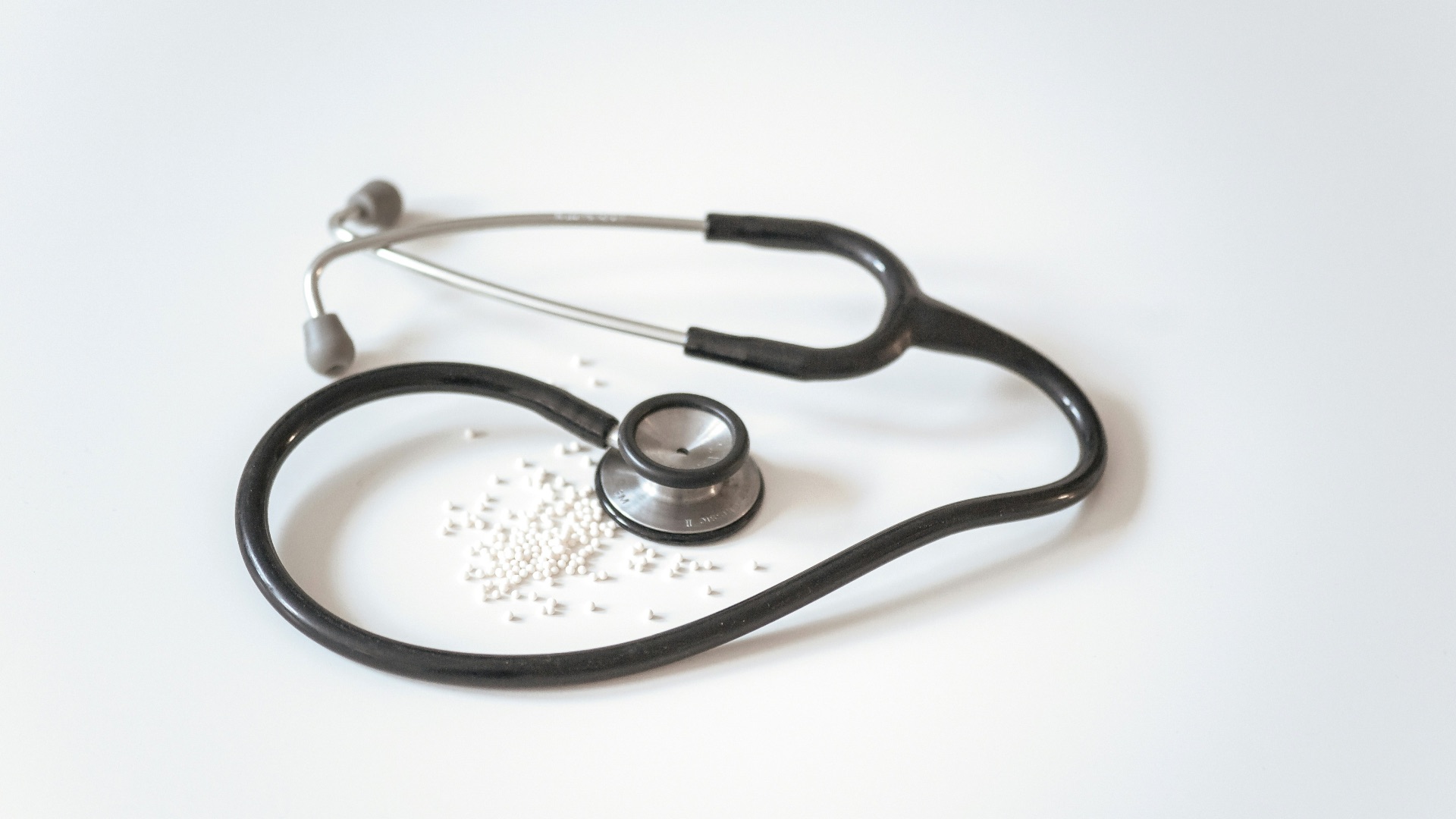 black and silver stethoscope on white surface