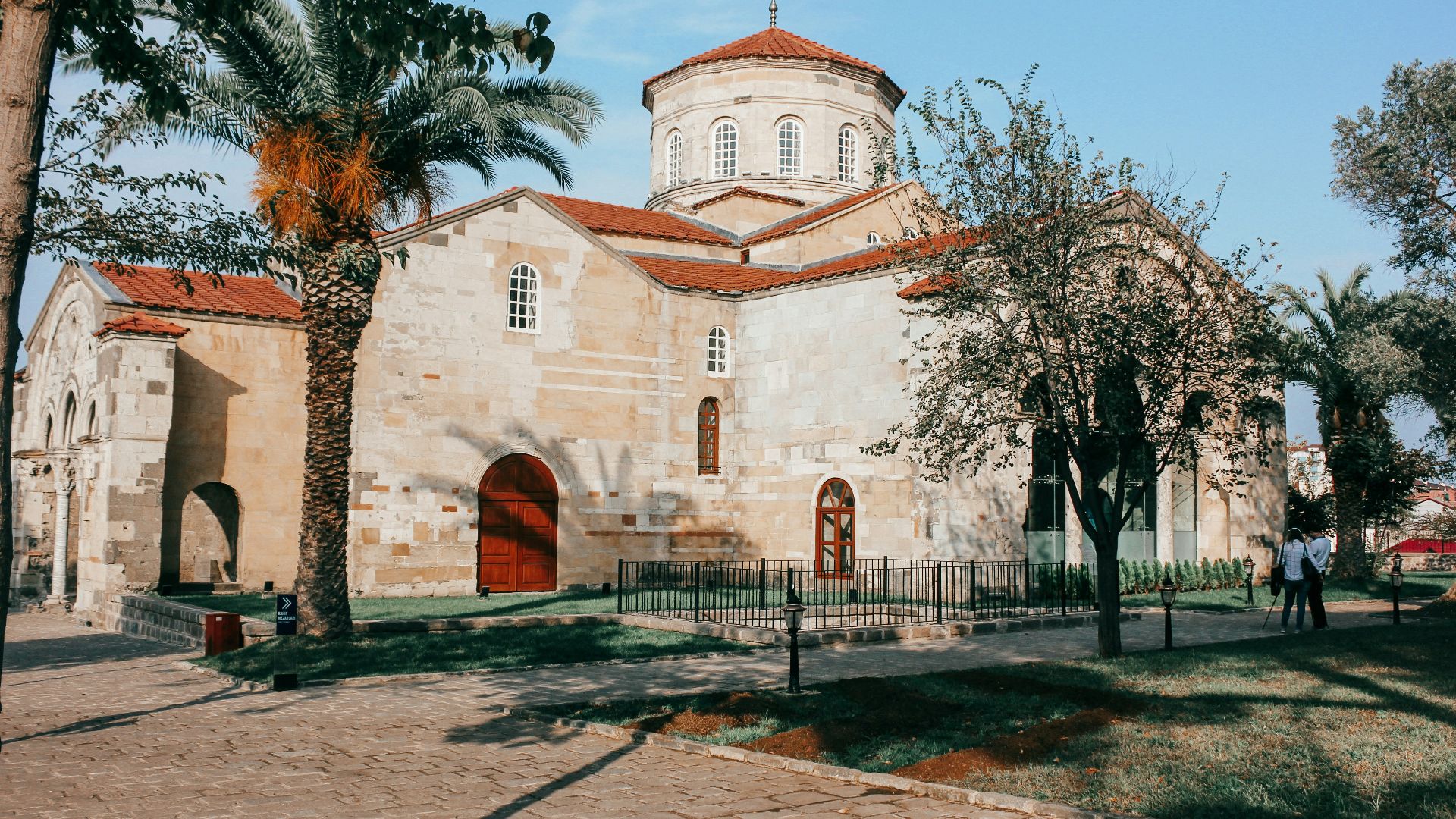 white and brown concrete building near trees under blue sky during daytime