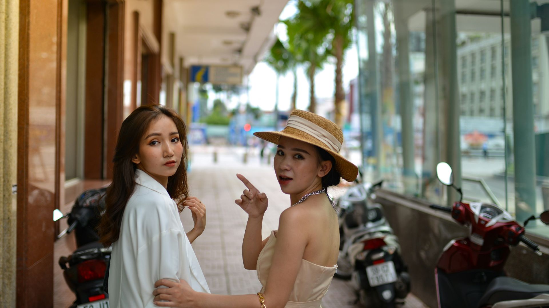 two women standing on a sidewalk talking to each other