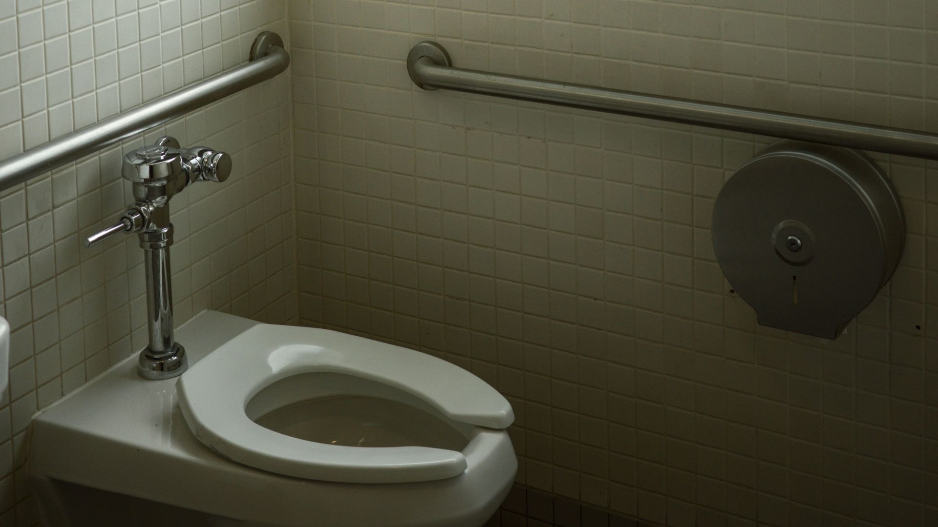 A white toilet sitting next to a window in a bathroom