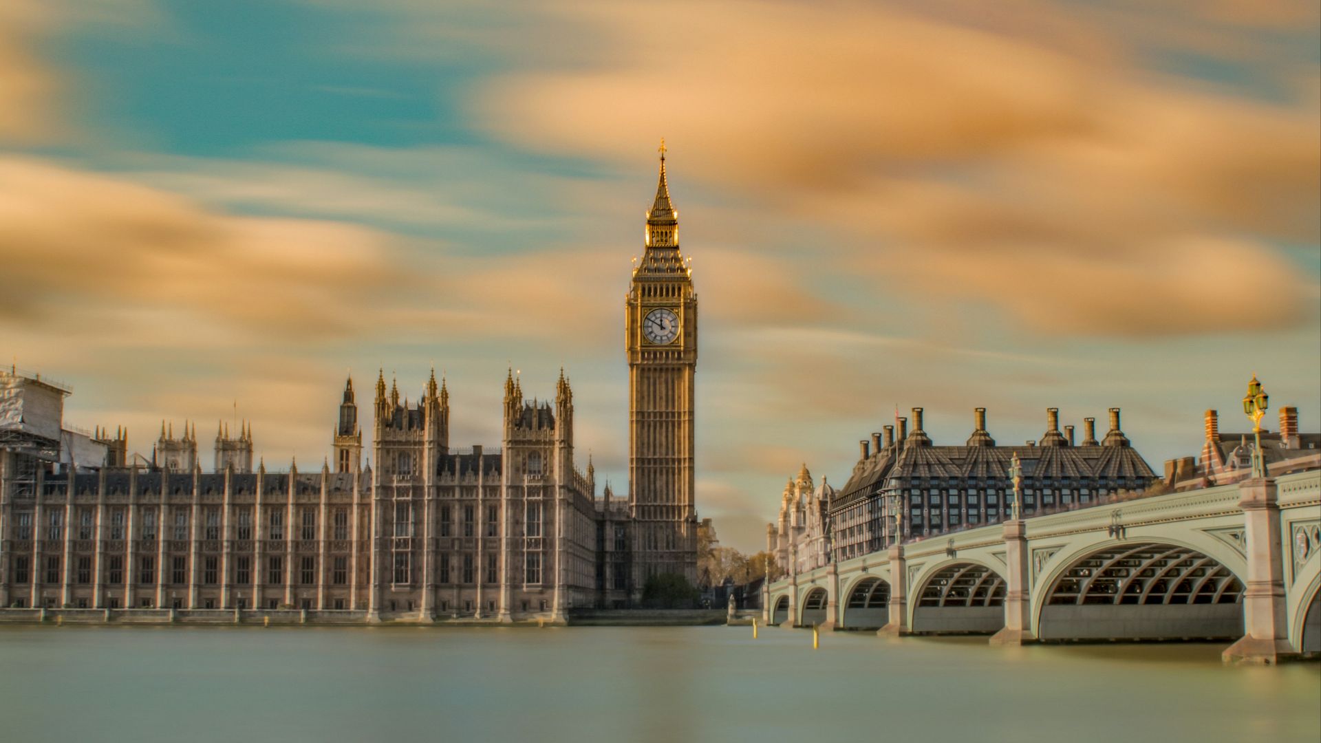 brown tower clock under cloudy sy