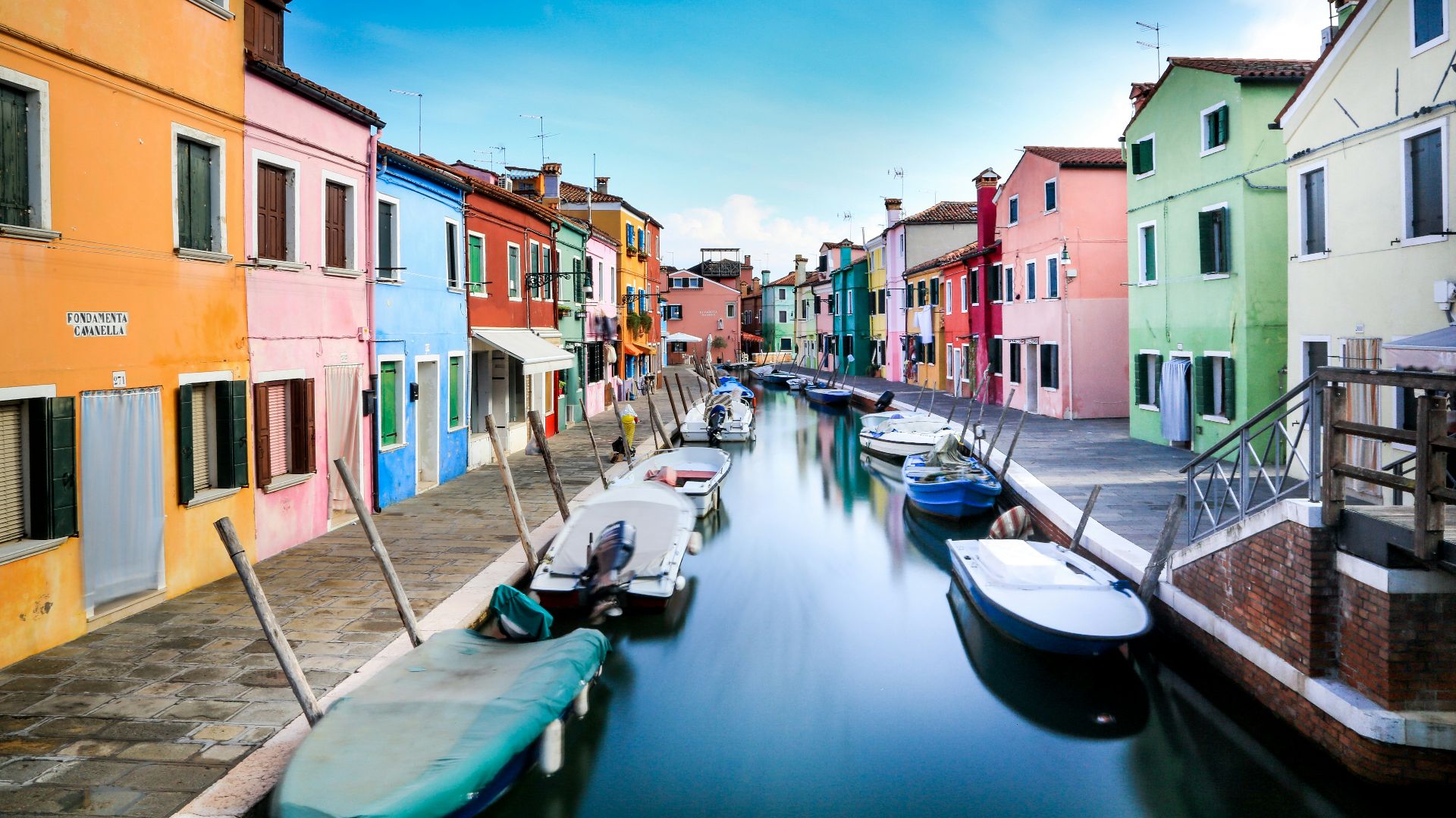 boats on canal between houses during daytime