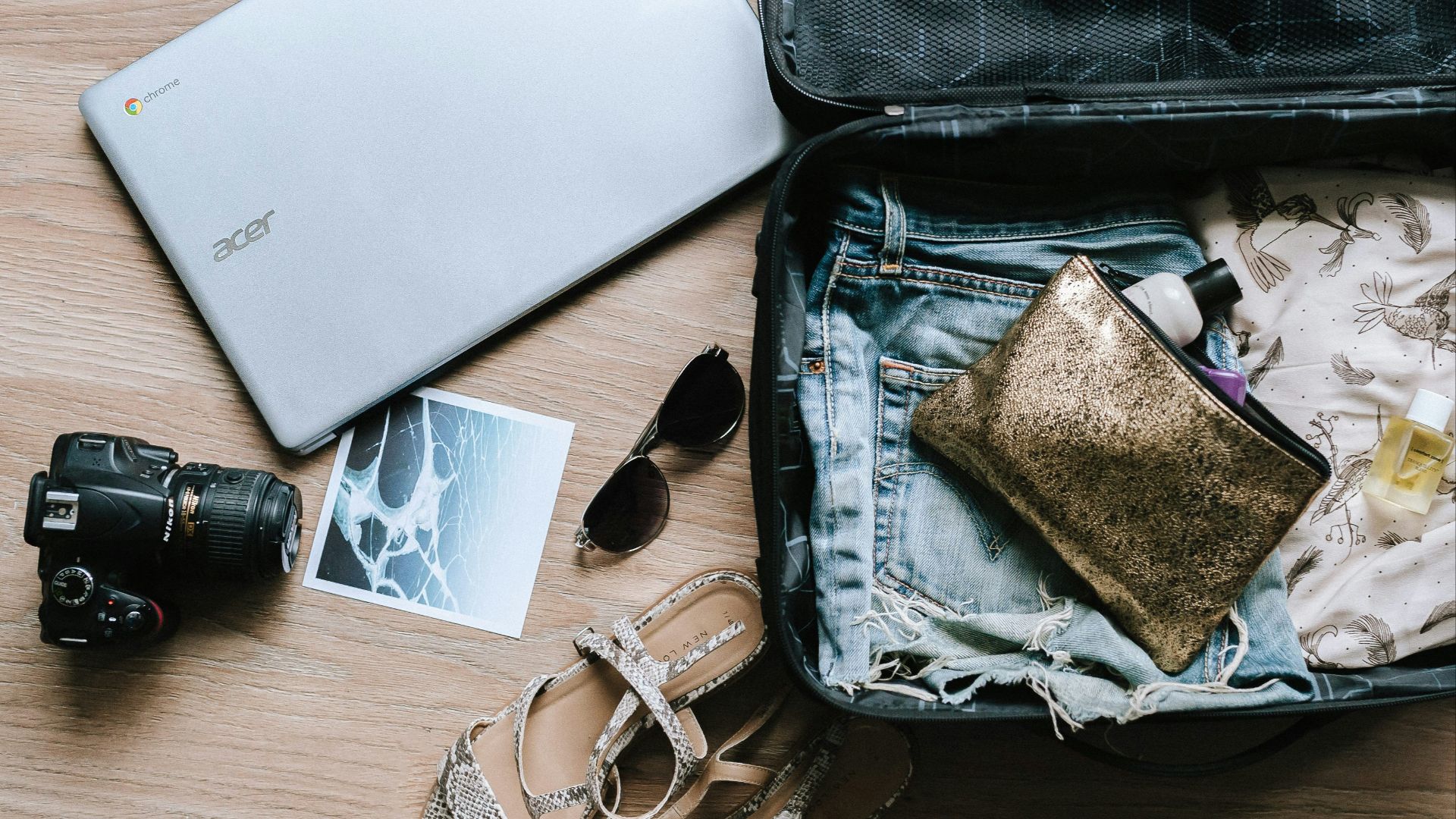 black DSLR camera near sunglasses and bag