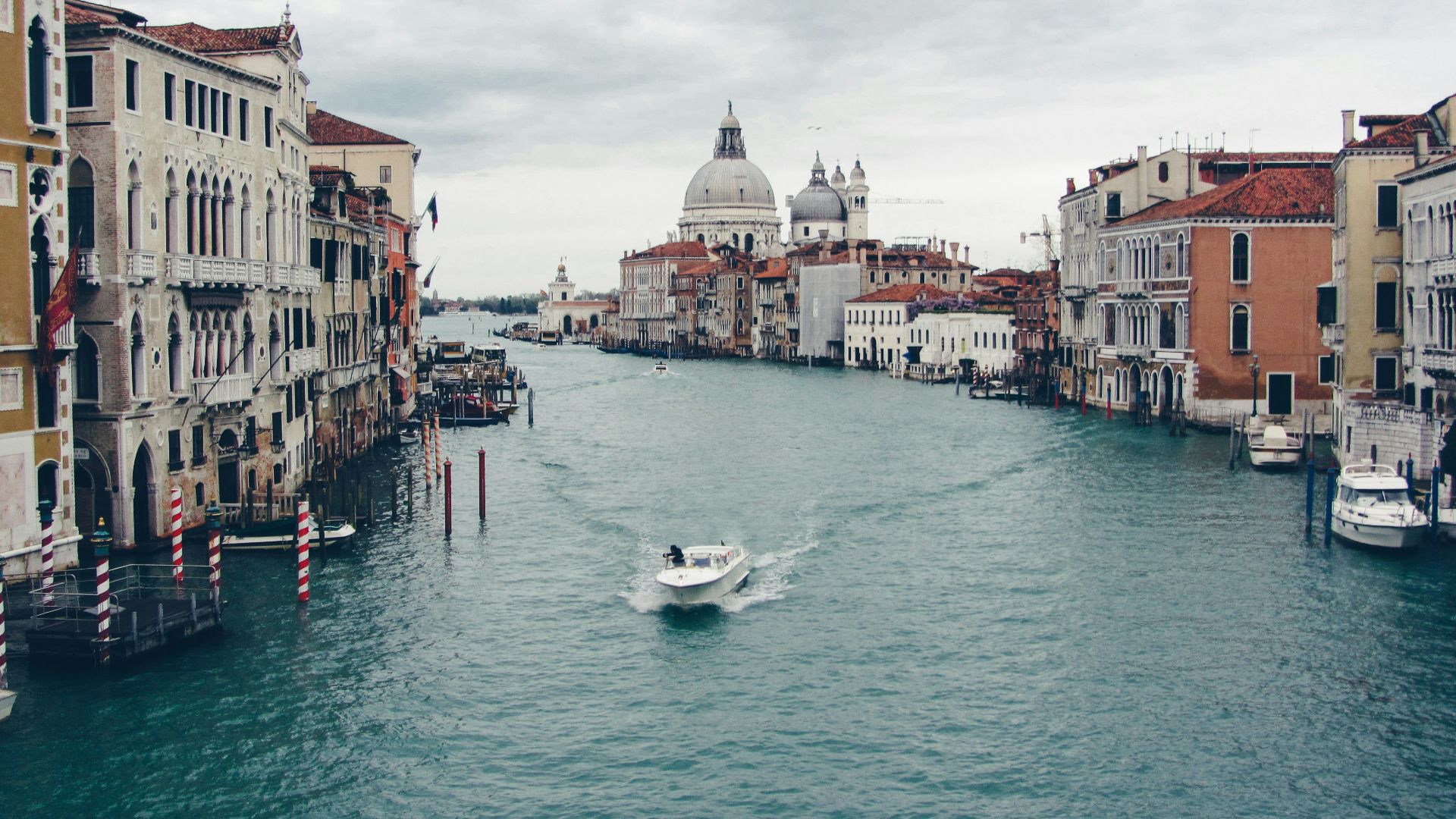 a boat traveling down a river next to tall buildings