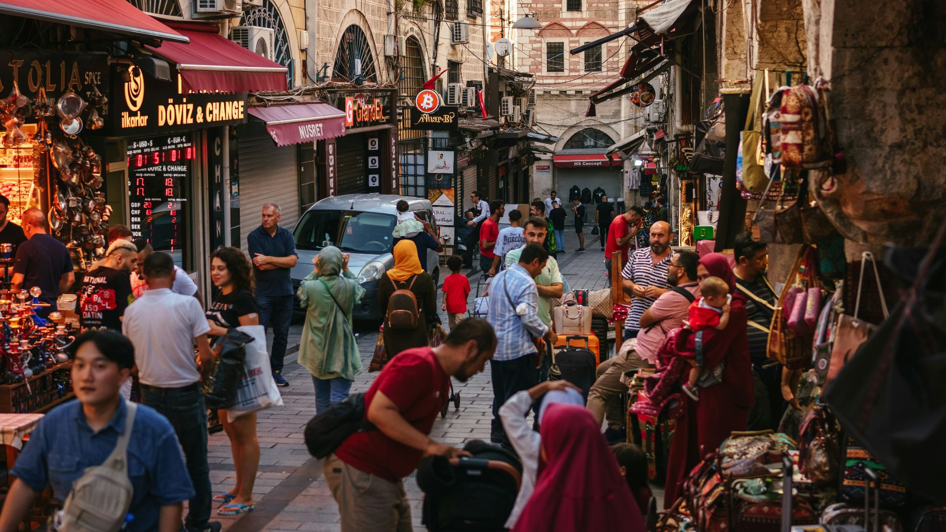 a crowd of people walking through a busy street