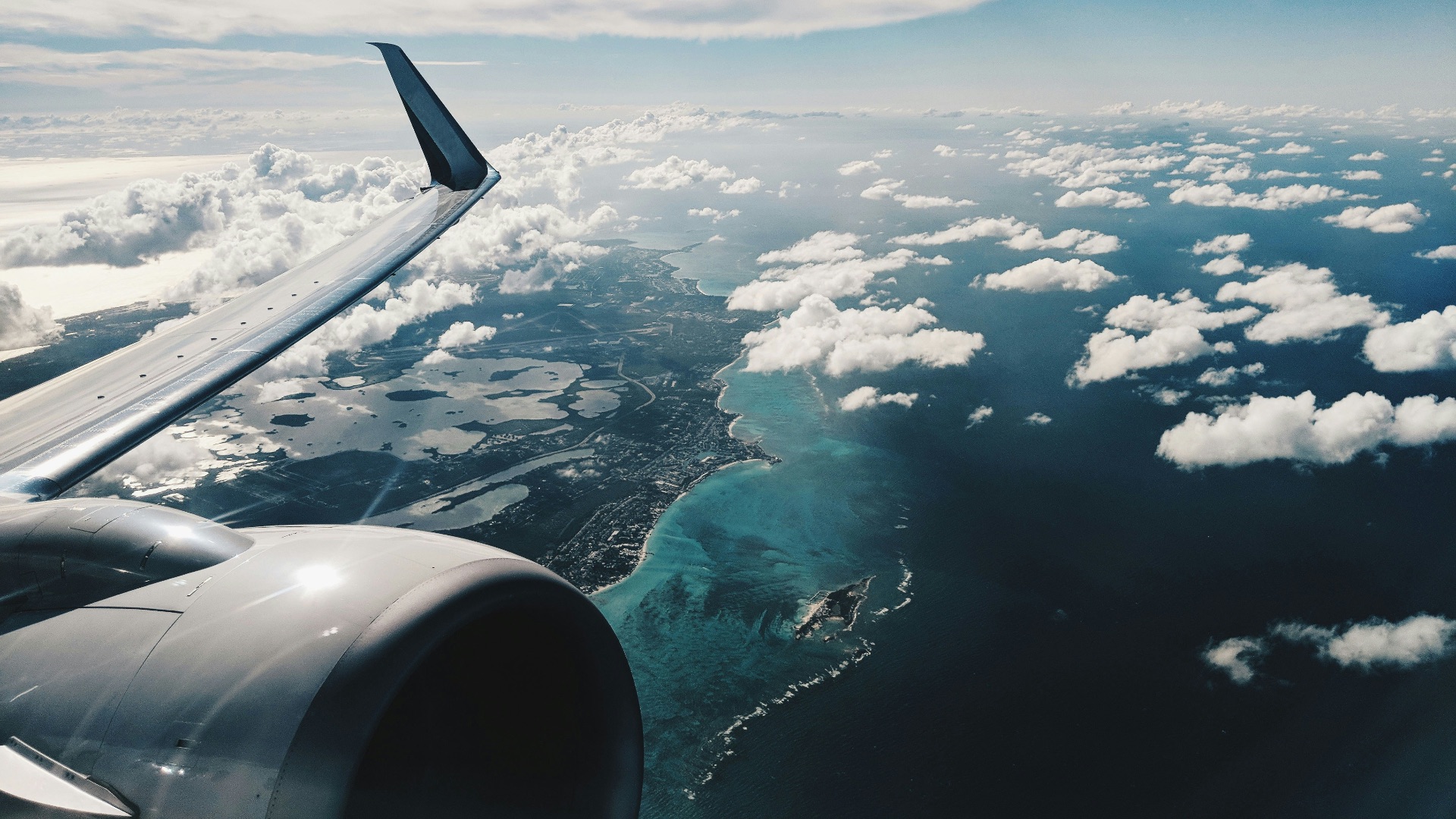photo of airplane wing under blue sky at daytime