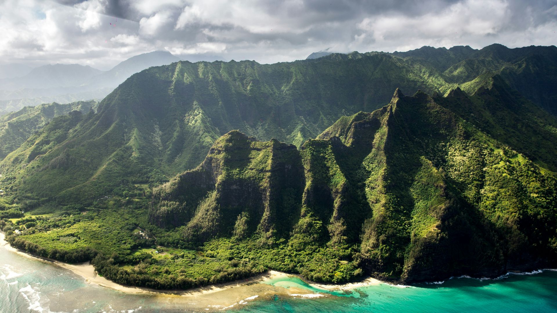 aerial photography of green mountain beside body of water under white sky