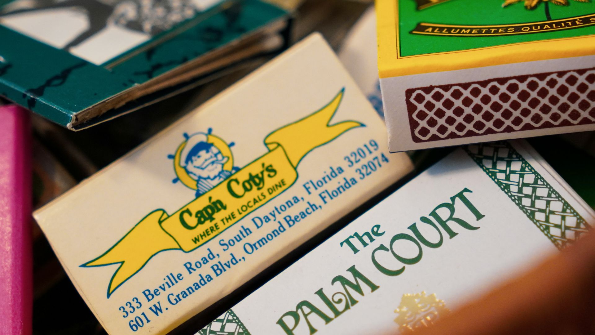 Many colorful matchboxes are piled together.