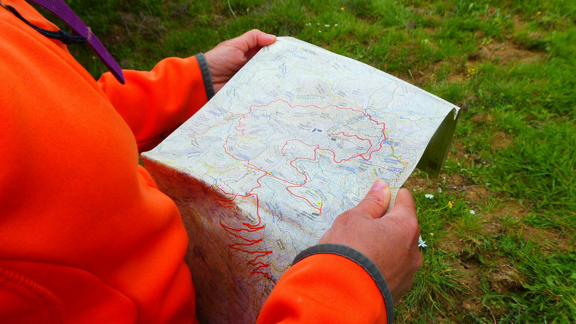 person in orange long sleeve shirt holding white printer paper
