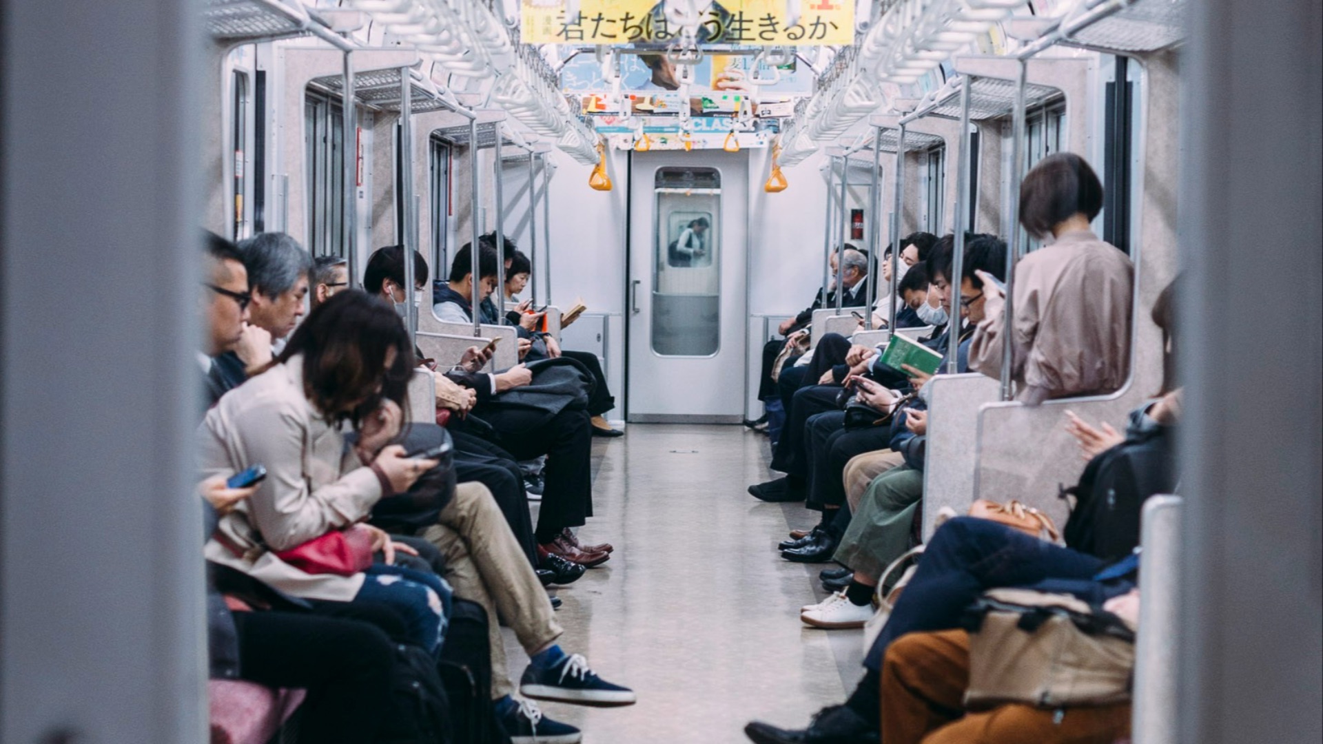 people at the train looking at their phones