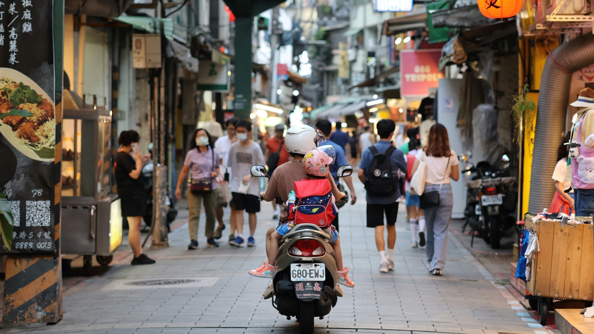a person on a scooter with a stuffed animal on the back of it