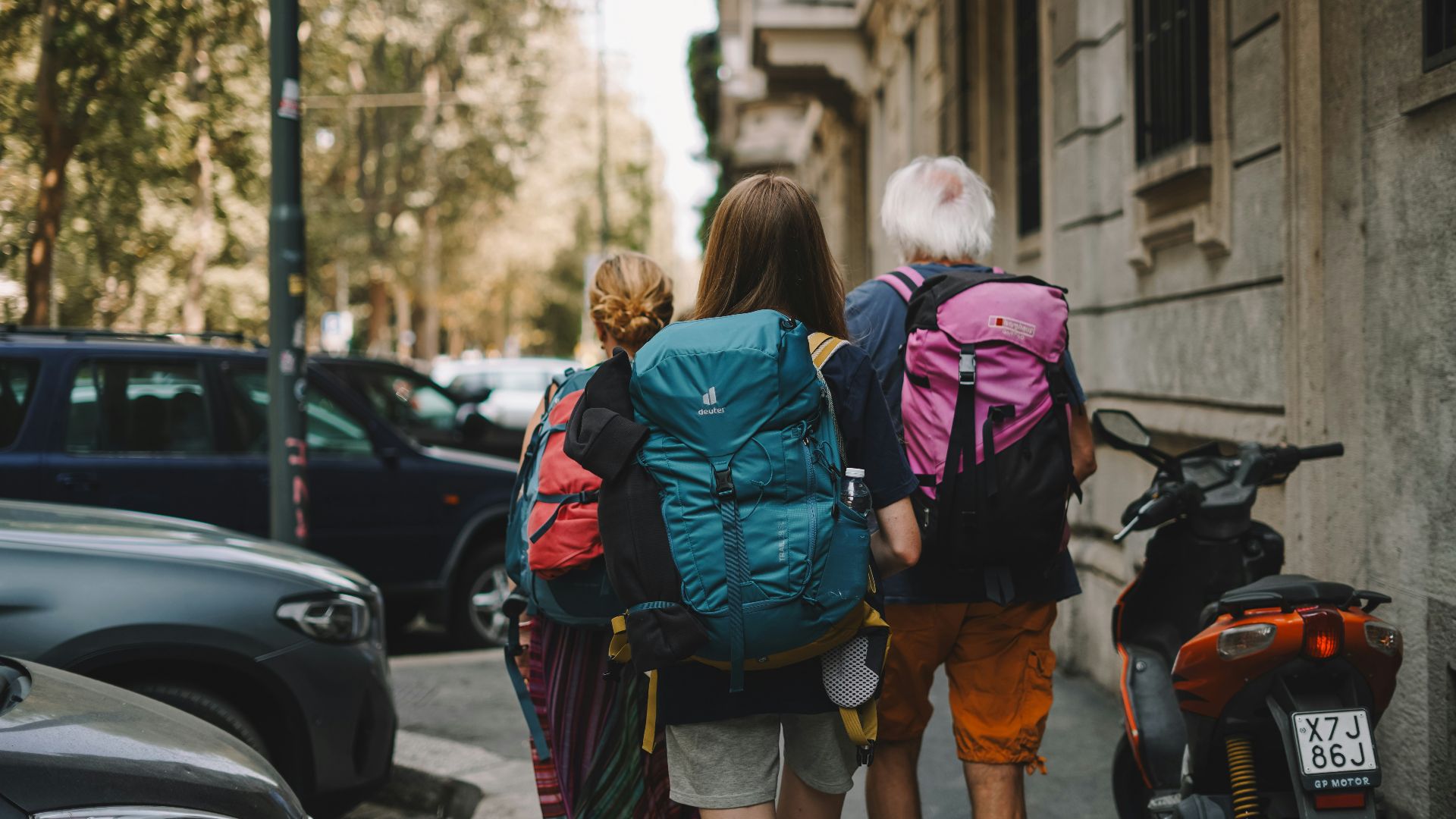 Two people with backpacks walking down the street