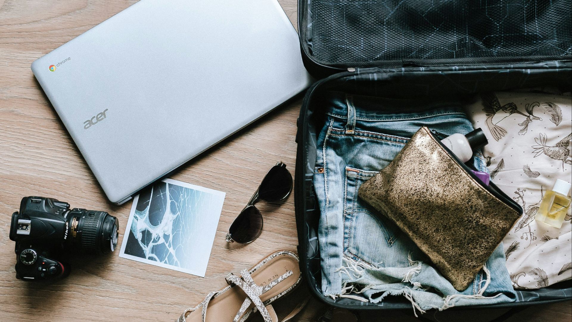 black DSLR camera near sunglasses and bag