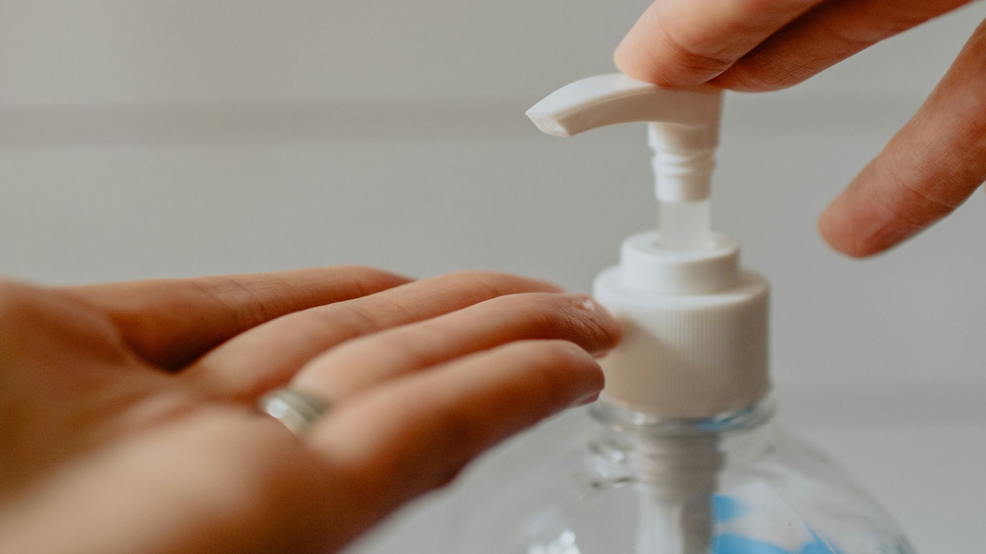 person holding white plastic pump bottle
