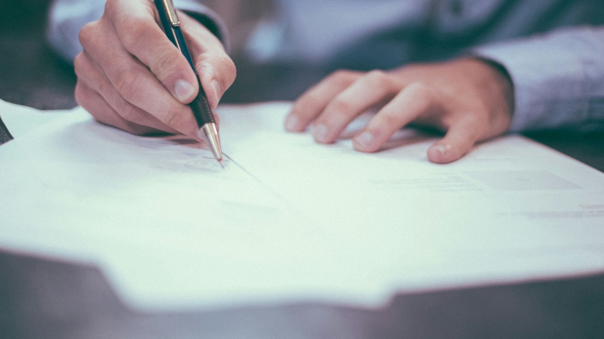 man writing on paper