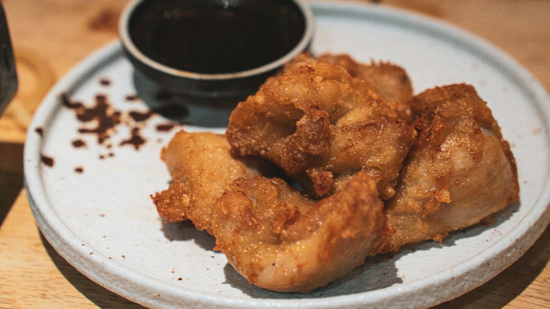 a white plate topped with fried food on top of a wooden table