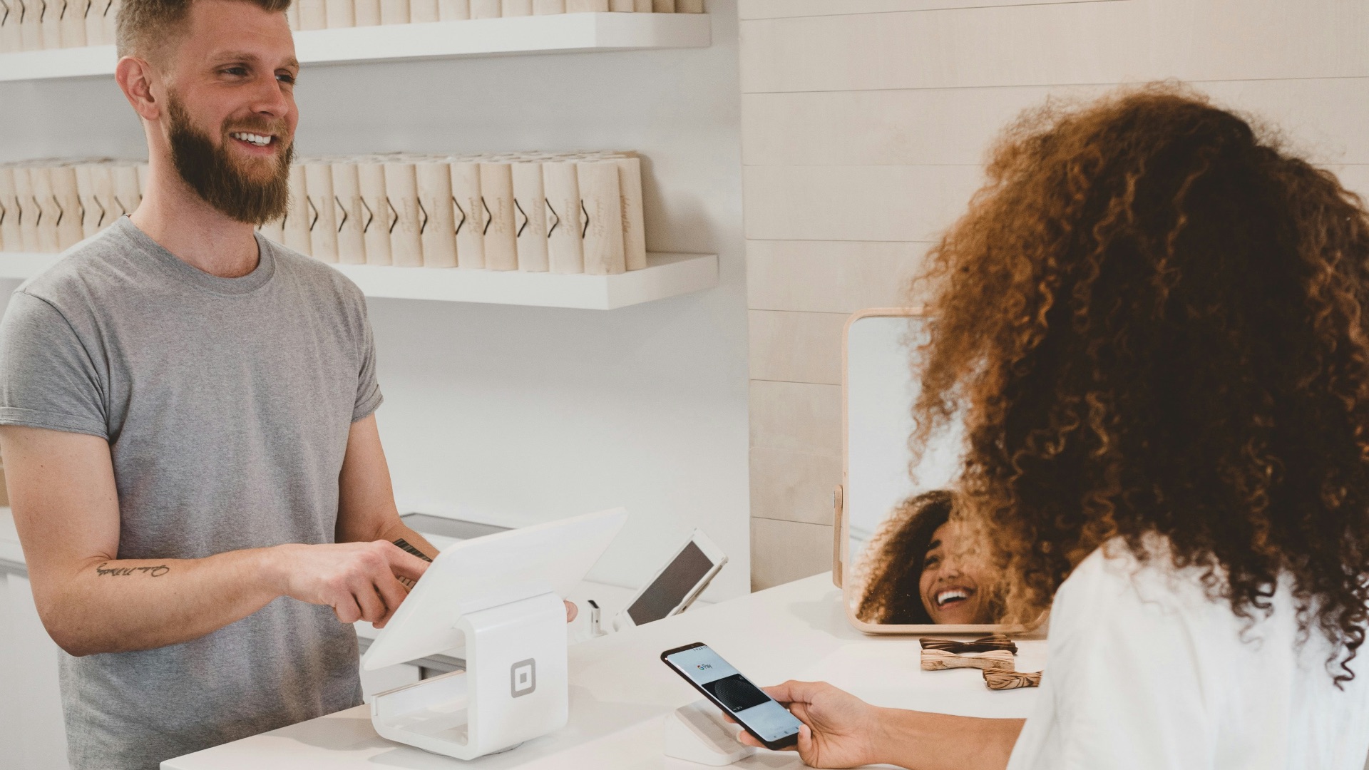 man in grey crew-neck t-shirt smiling to woman on counter