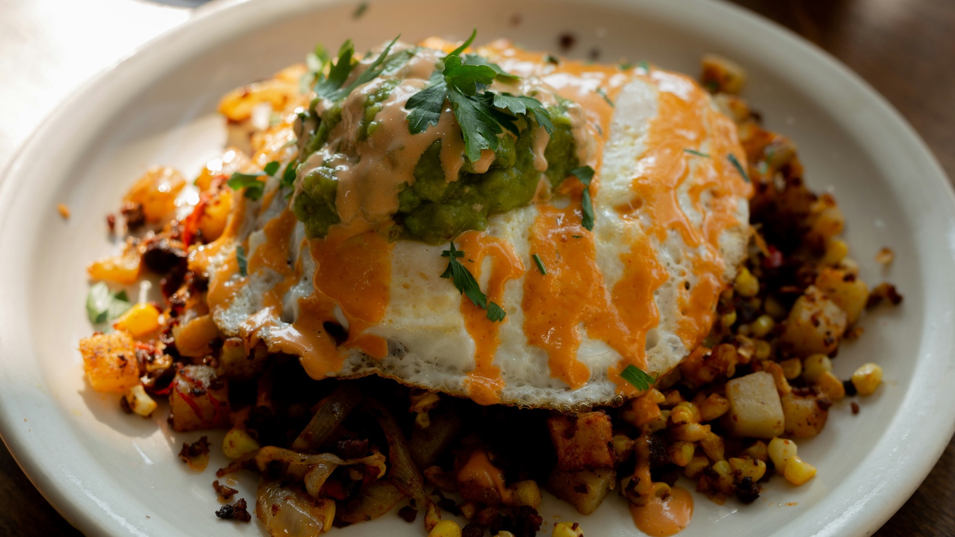 a white plate topped with an egg covered in toppings
